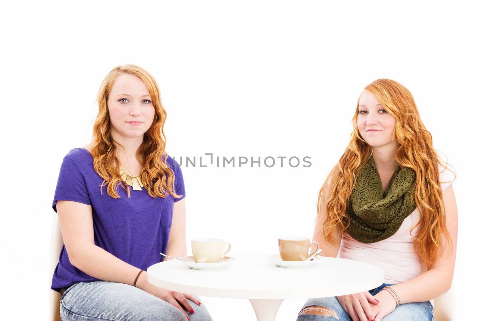 charming young redhead women sitting at a coffee table on white background