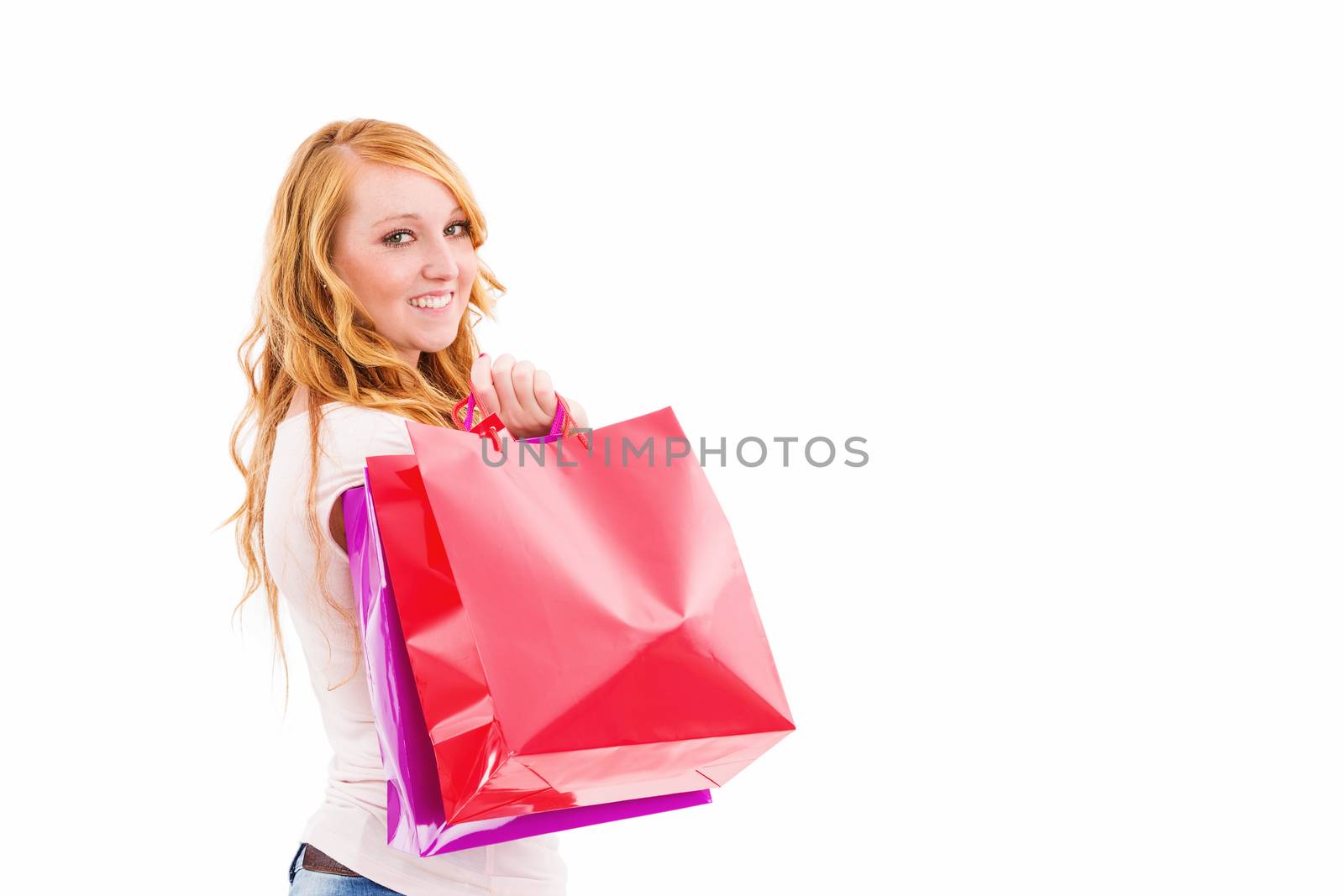 young redhead woman with shopping bags turning around on white background