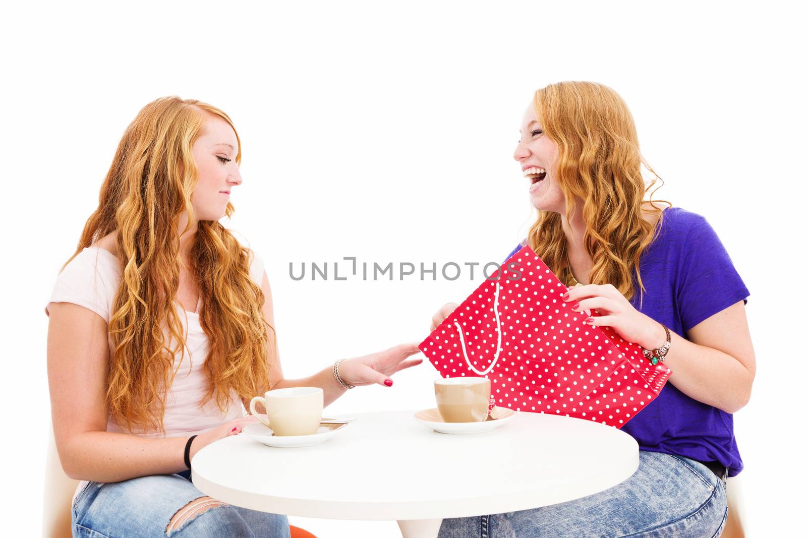 jealous woman looking at the shopping bag of her happy friend on white background