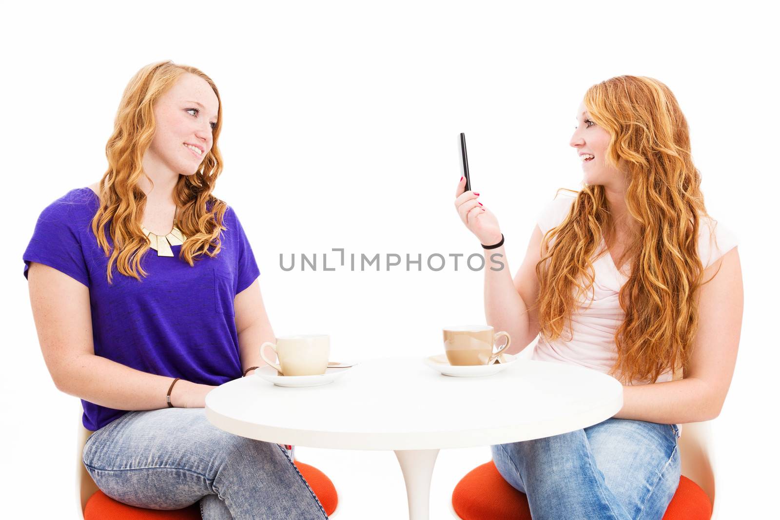 young redhead woman making photos of her cute friend on white background