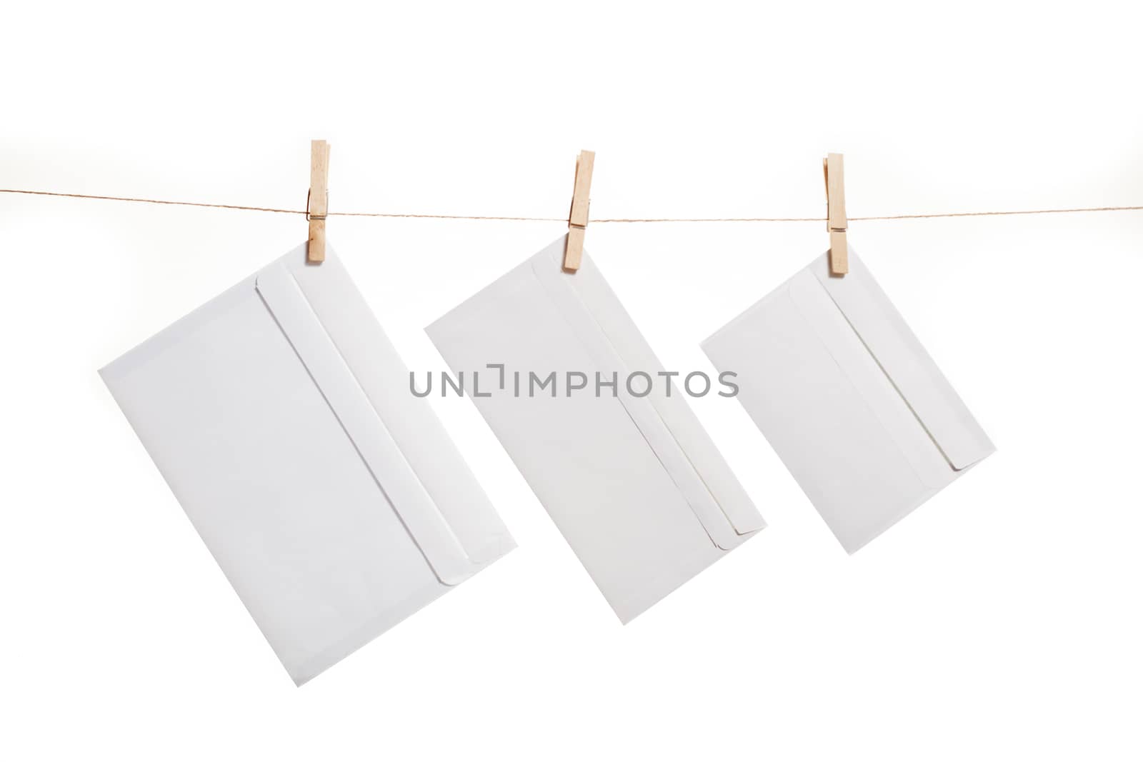 Three envelope held by clothespins on a string