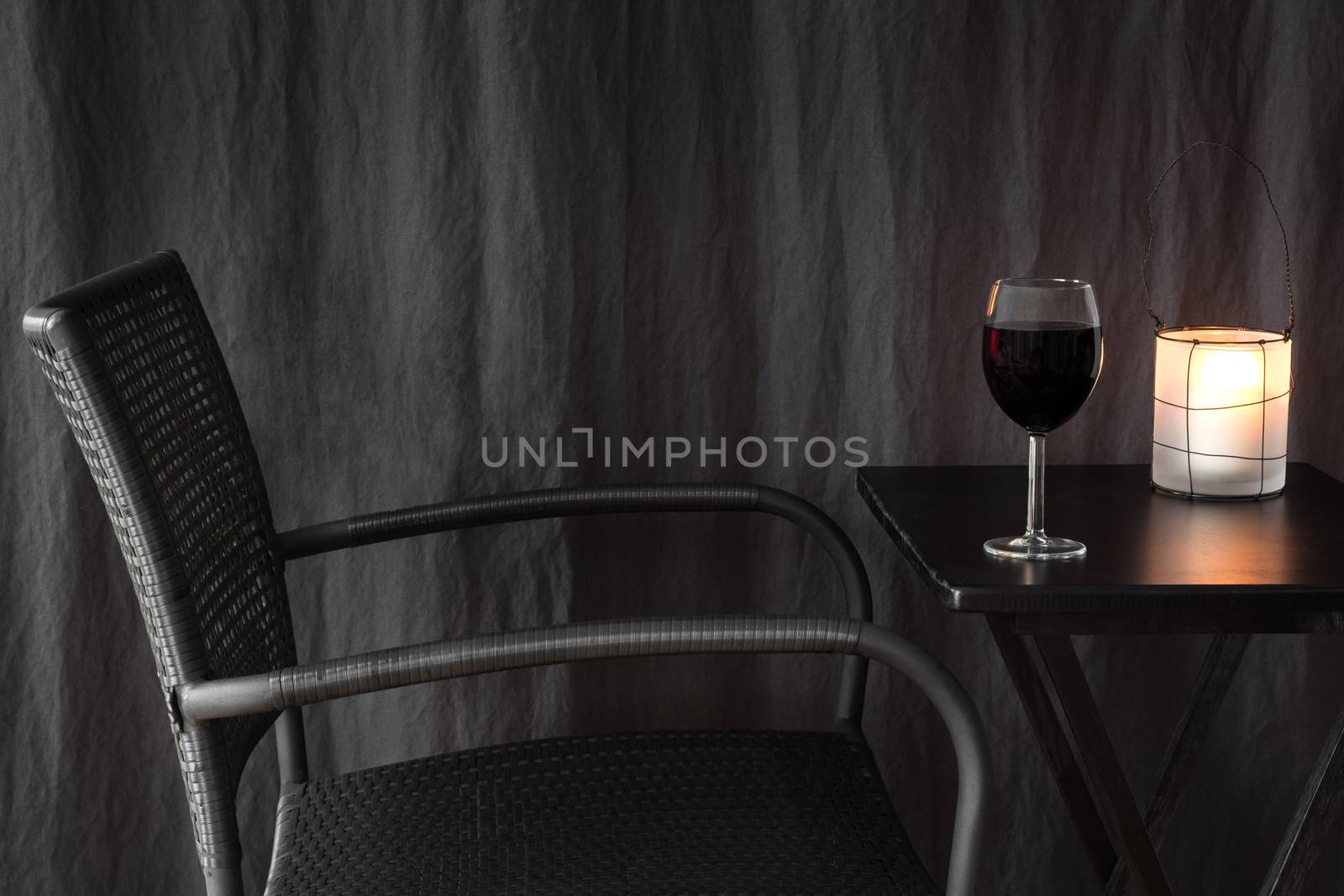 Cozy lantern decorating a table with glass of red wine.