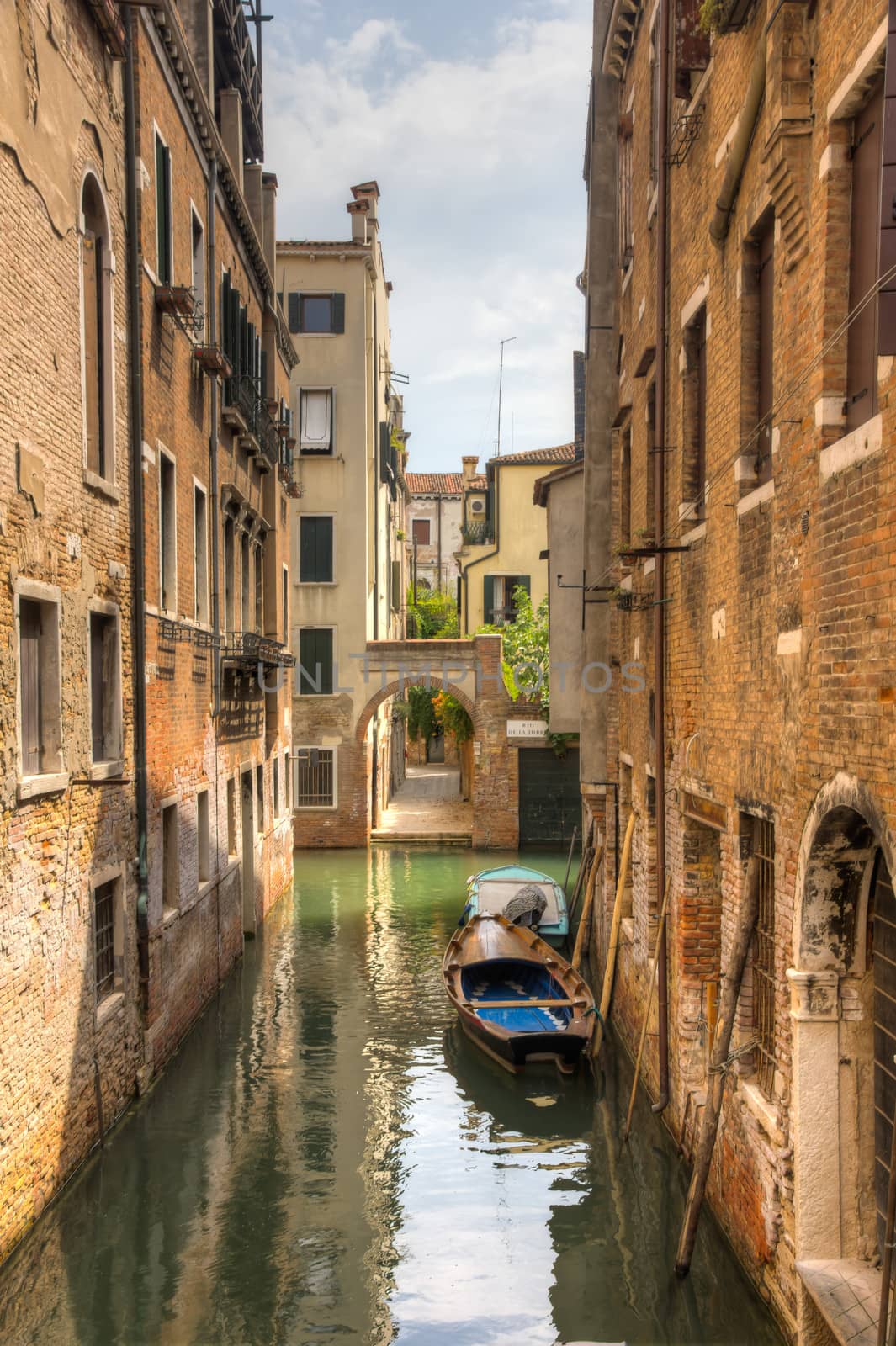 Canal in venezia with a boat in the middle