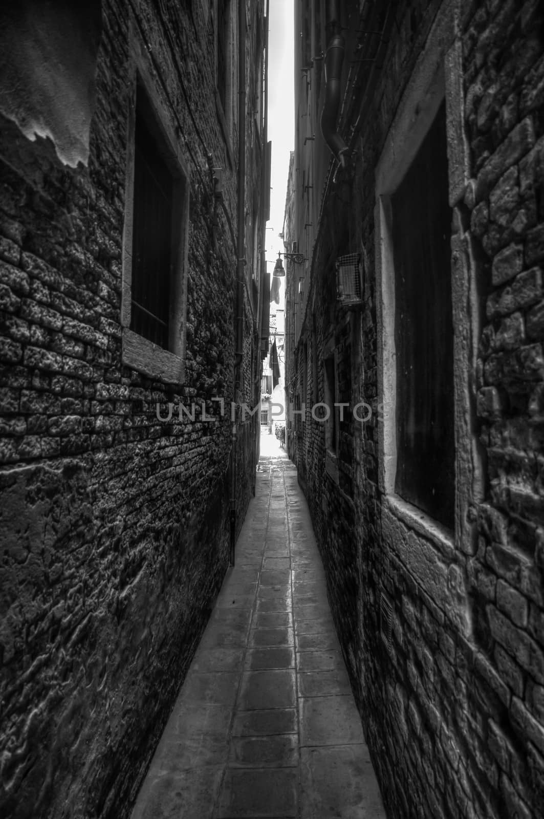 B&W picture of a narrow alleyway in Venezia