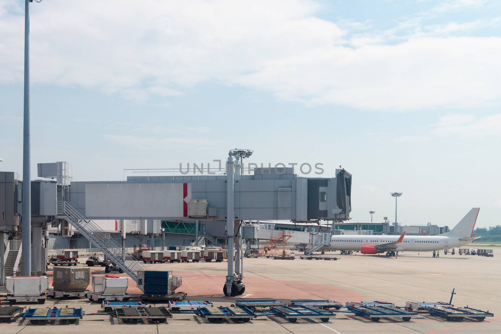 Empty jetway with airplane at the airport on loading on background