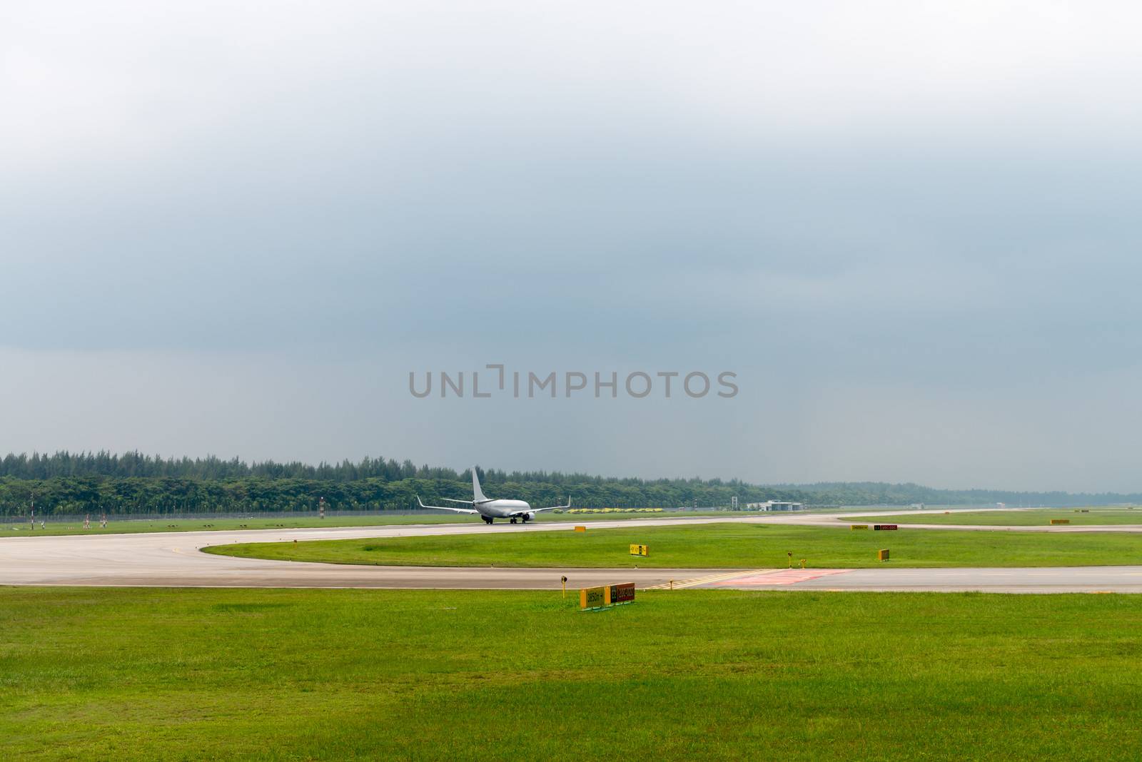 Plane speed up on airport runway in modern airport under cloudy sky