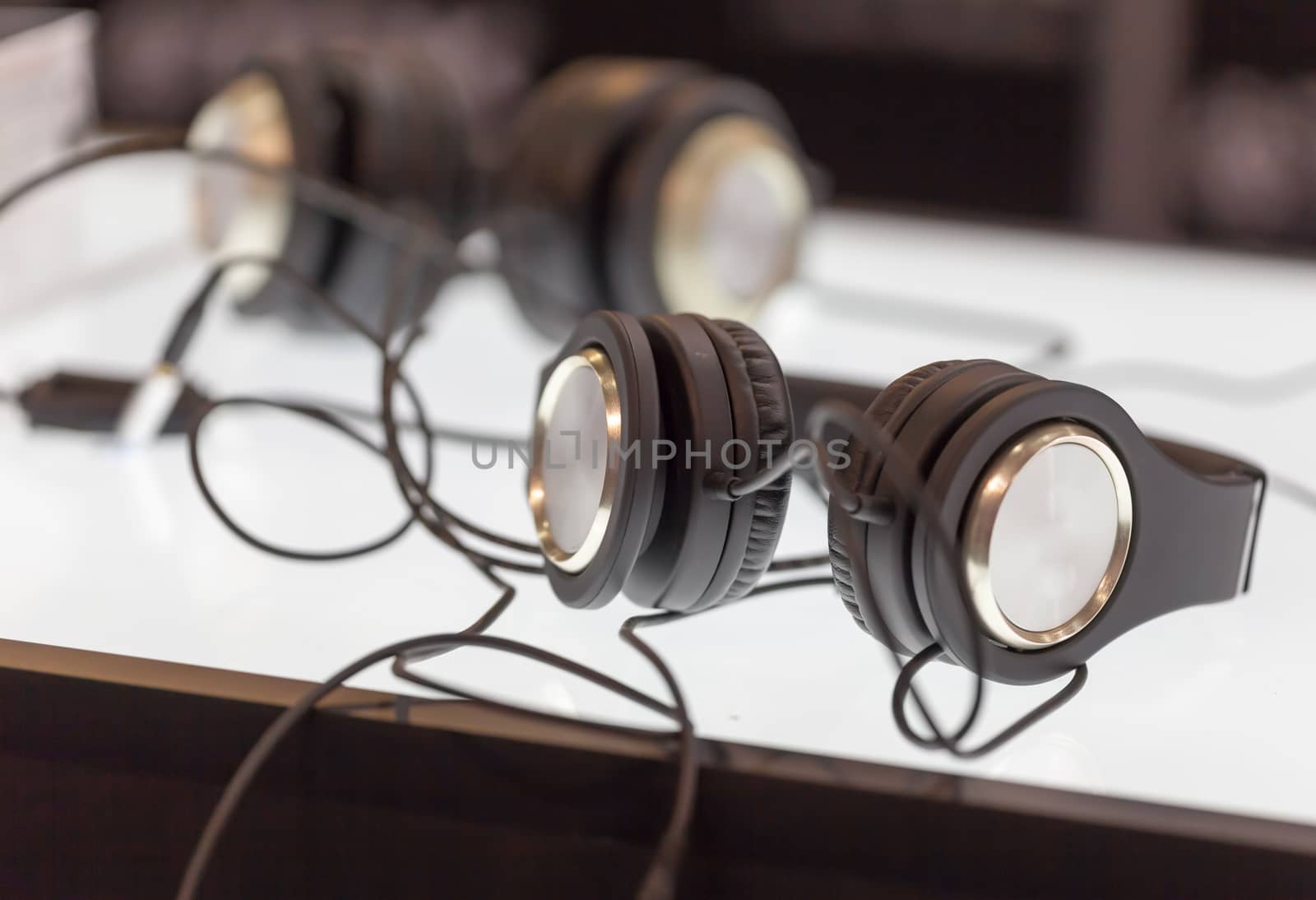 Two pair black headphones on table by tdhster
