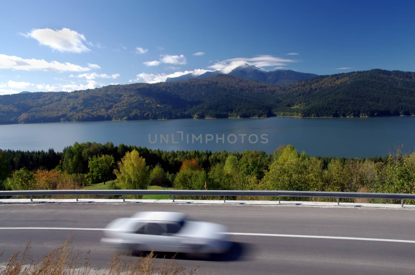 Moving car on road in autumn mountain landscape