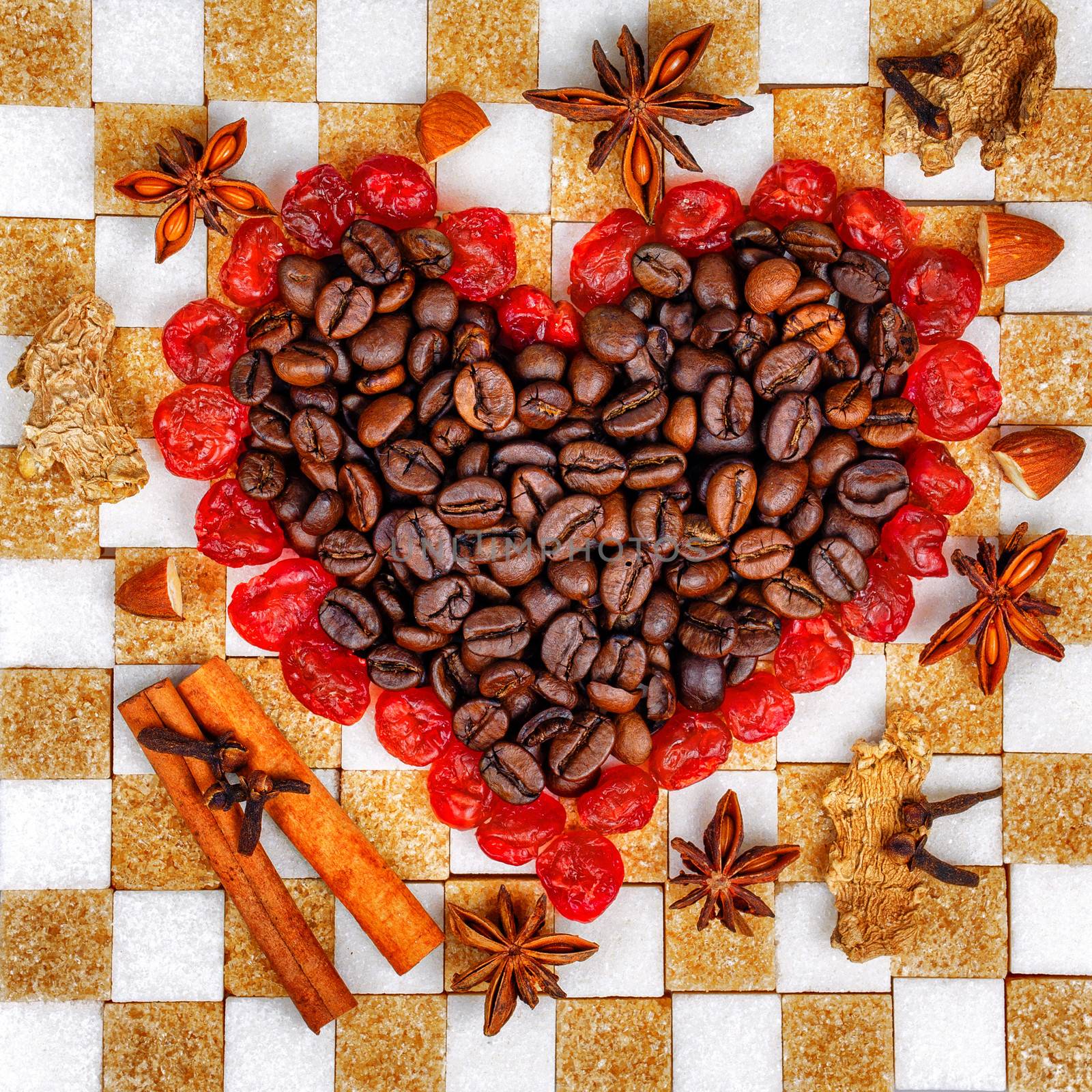 Heart of the coffee and cherries laid out on chessboard made of sugar cubes
