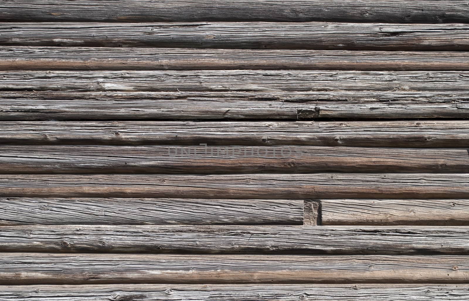 Fragment of old weathered log wall, useful as background