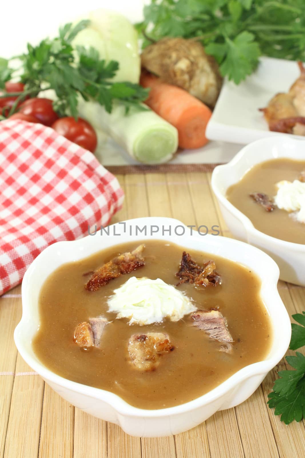 white bowls with duck soup and cream