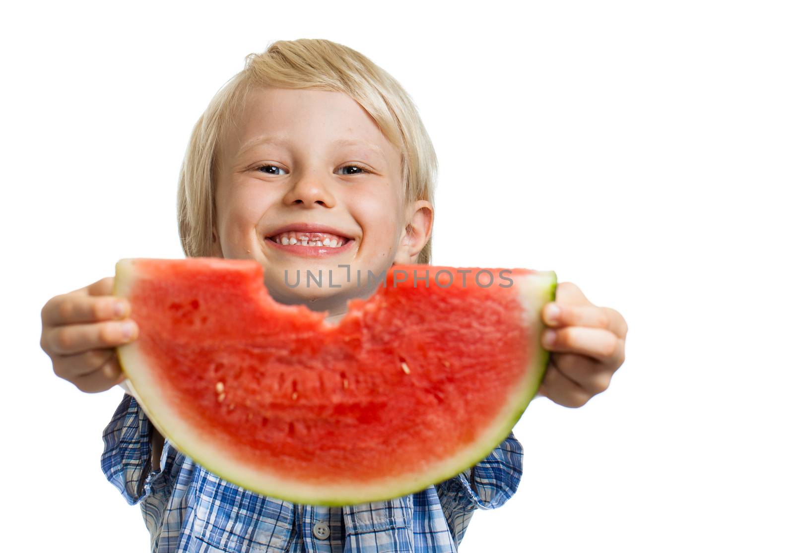 A cute smiling boy holding out and peeking through a bite in a slice water melon. Isolated on white.