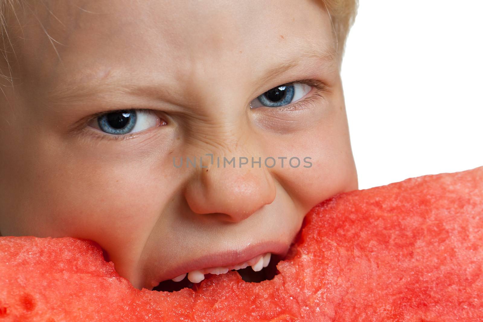 A close-up shot of boy taking big bite a big juicy slice of watermelon. Isolated on white.