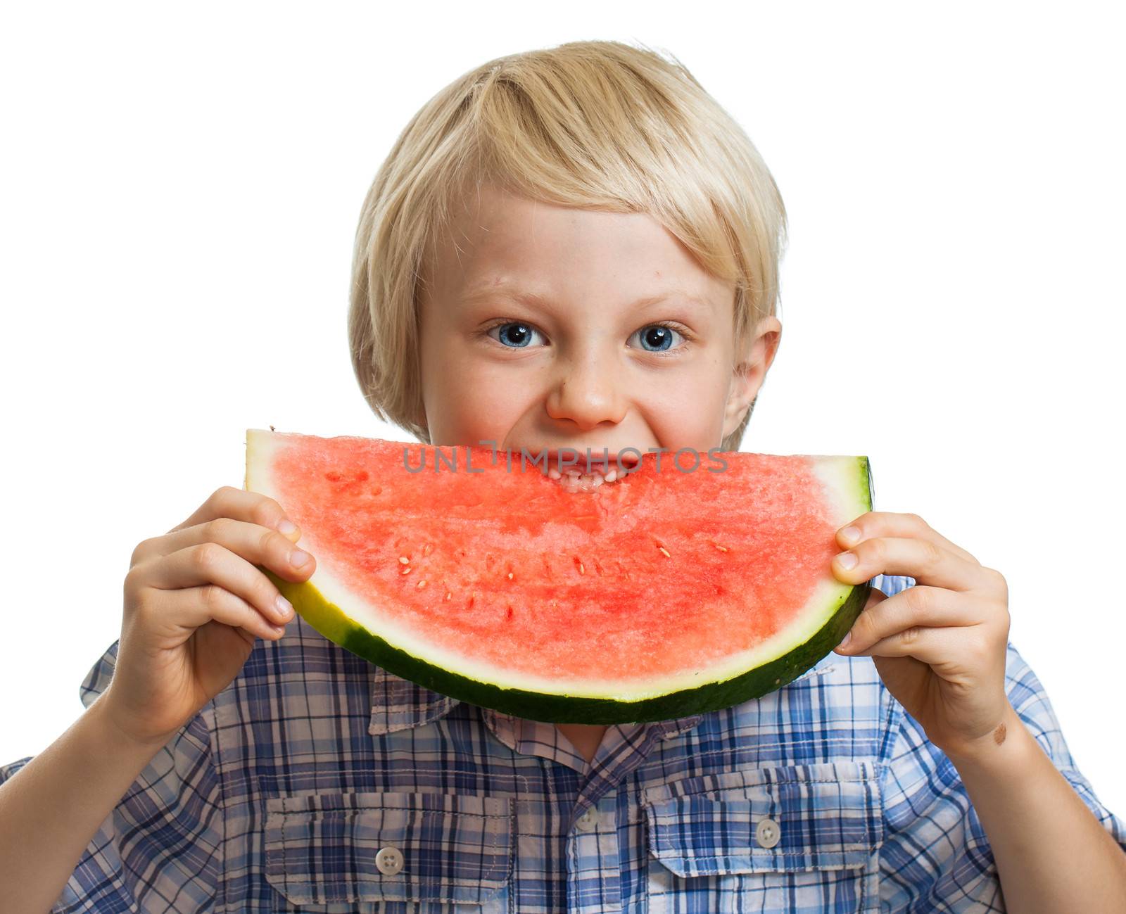 A cute happy smiling boy biting into a big juicy slice of watermelon. Isolated on white.