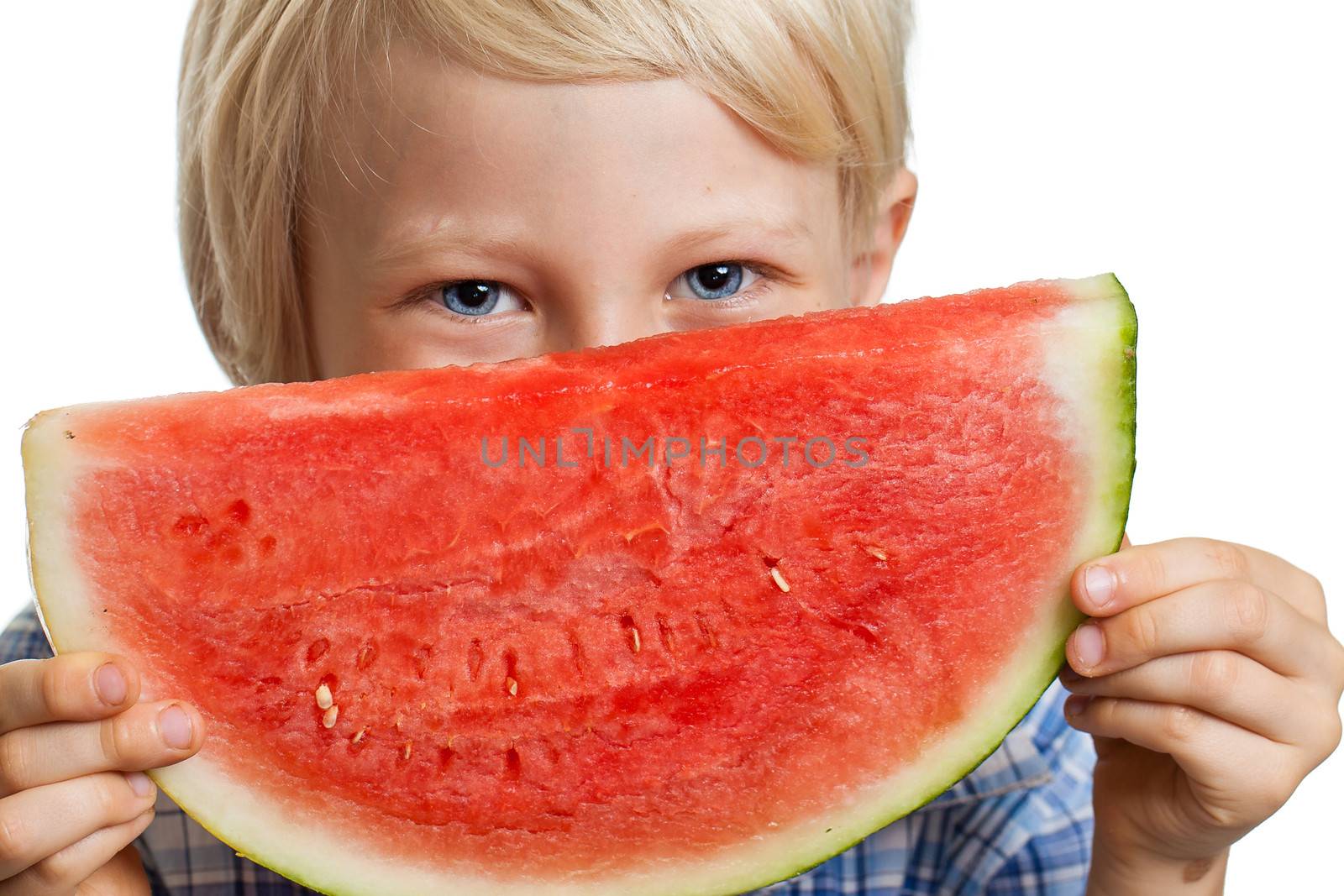 Close-up shot of a cute happy smiling boy peeking over a juicy  slice of watermelon. Isolated on white.