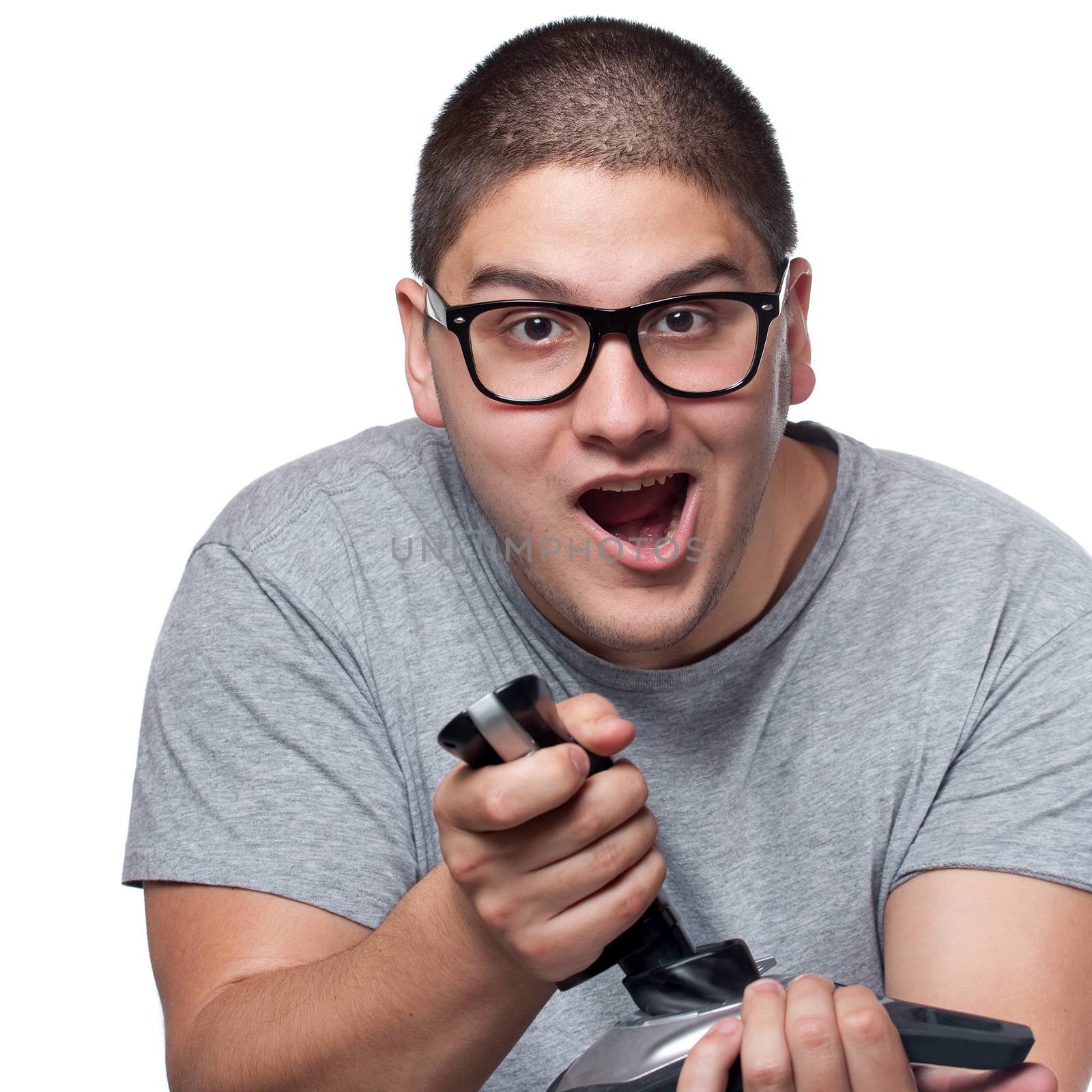 A fun loving video gamer playing with a wireless joystick over a white background.