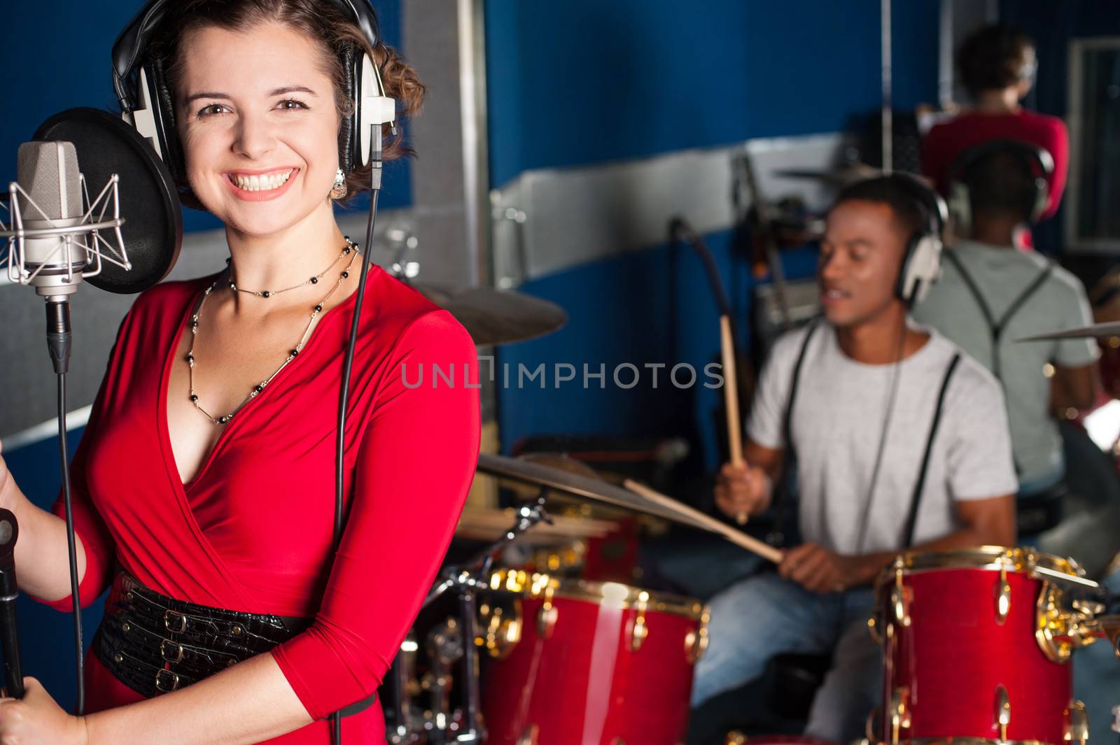 Female singer recording a track in studio by stockyimages