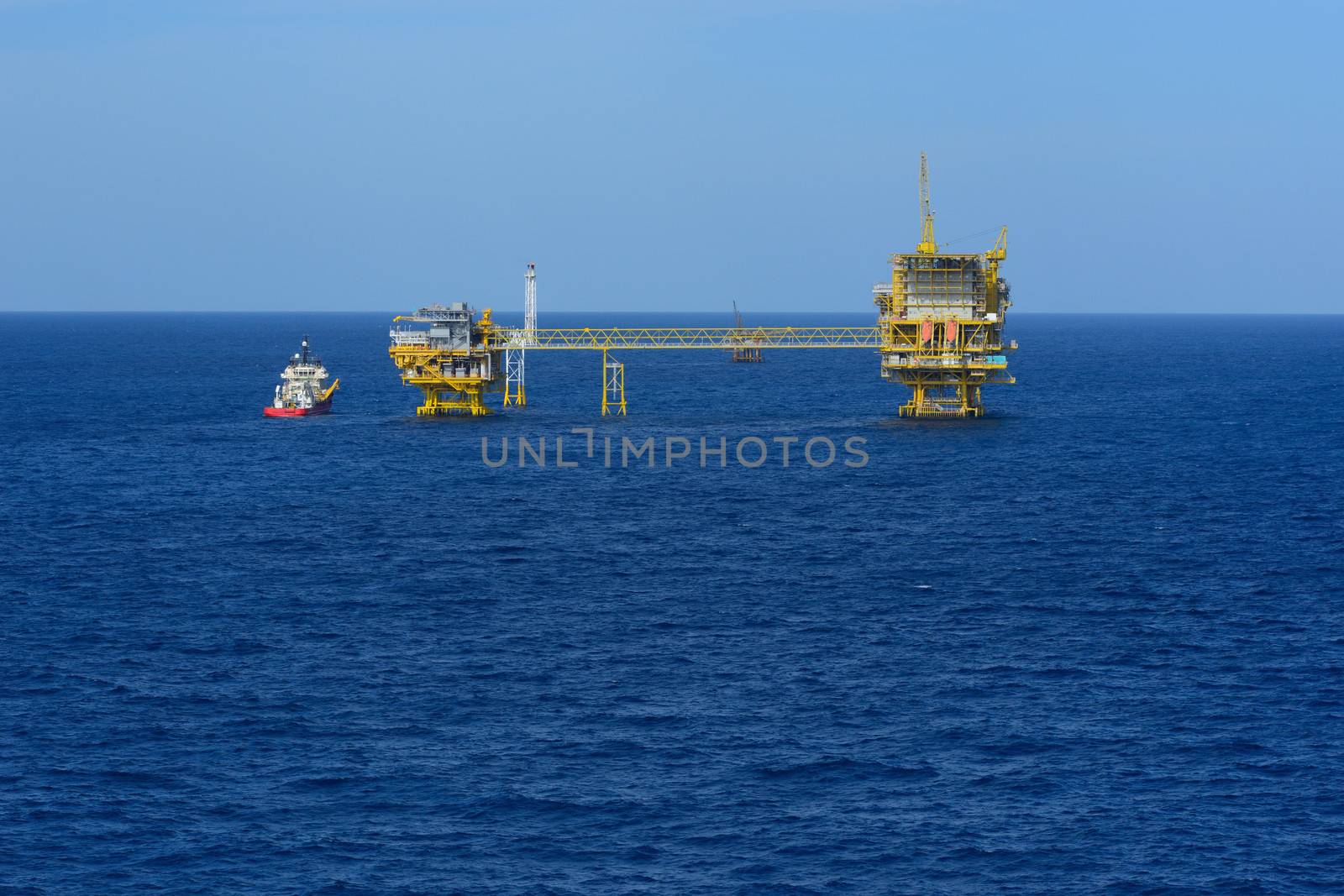 The offshore drilling oil rig and supply boat