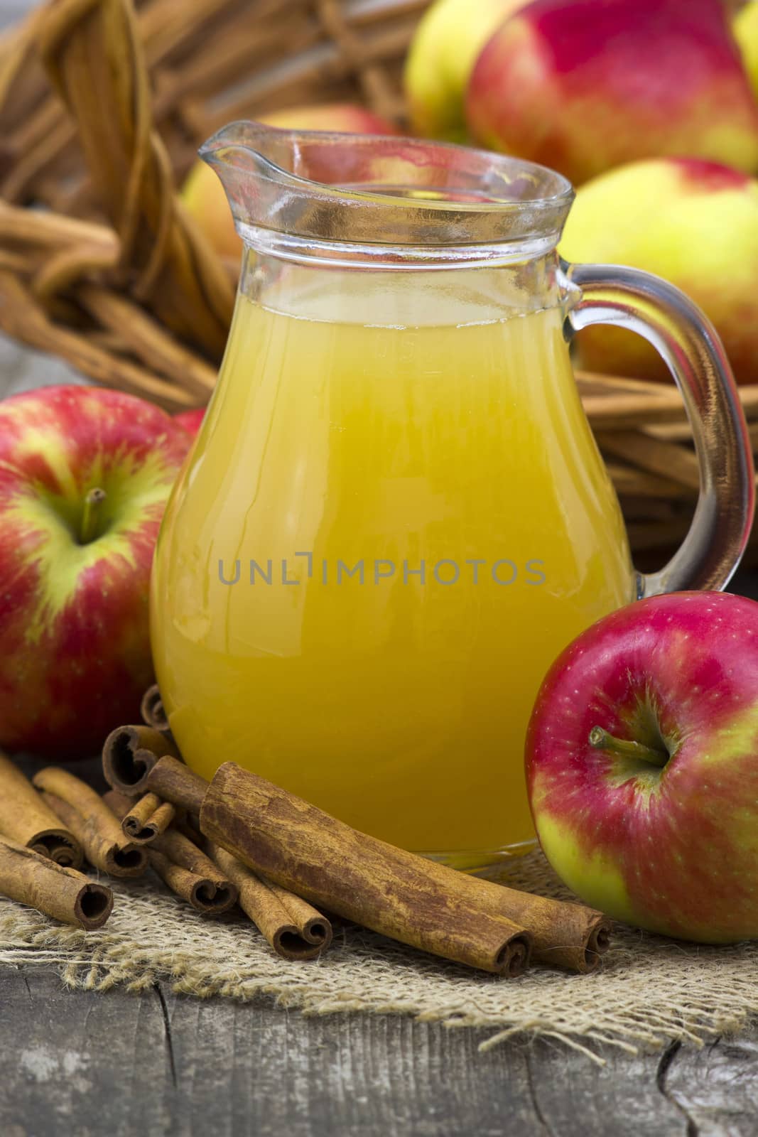 Apple juice and apples on wooden background