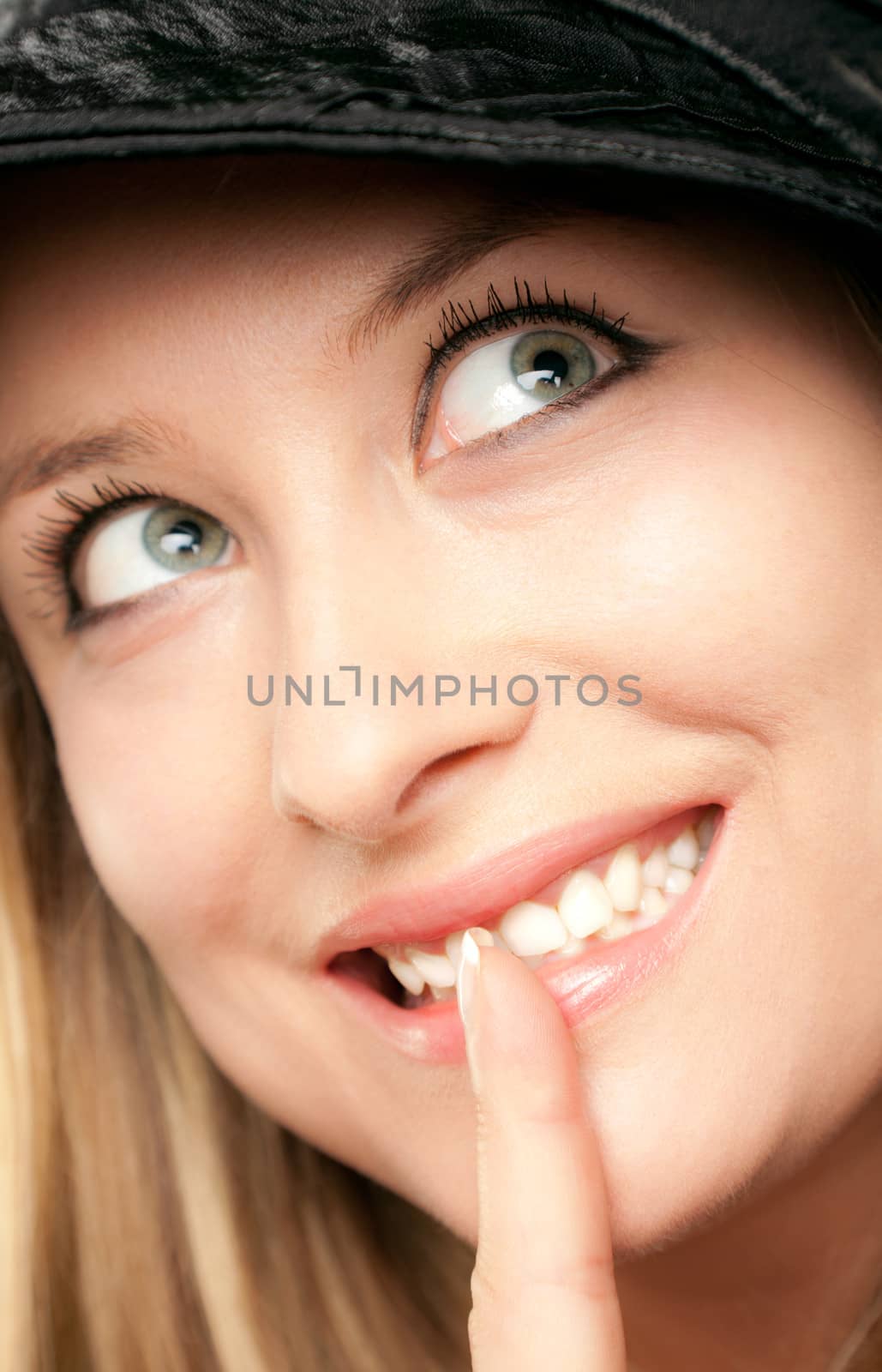 Portrait of smiling blond woman face showing shush, looking up