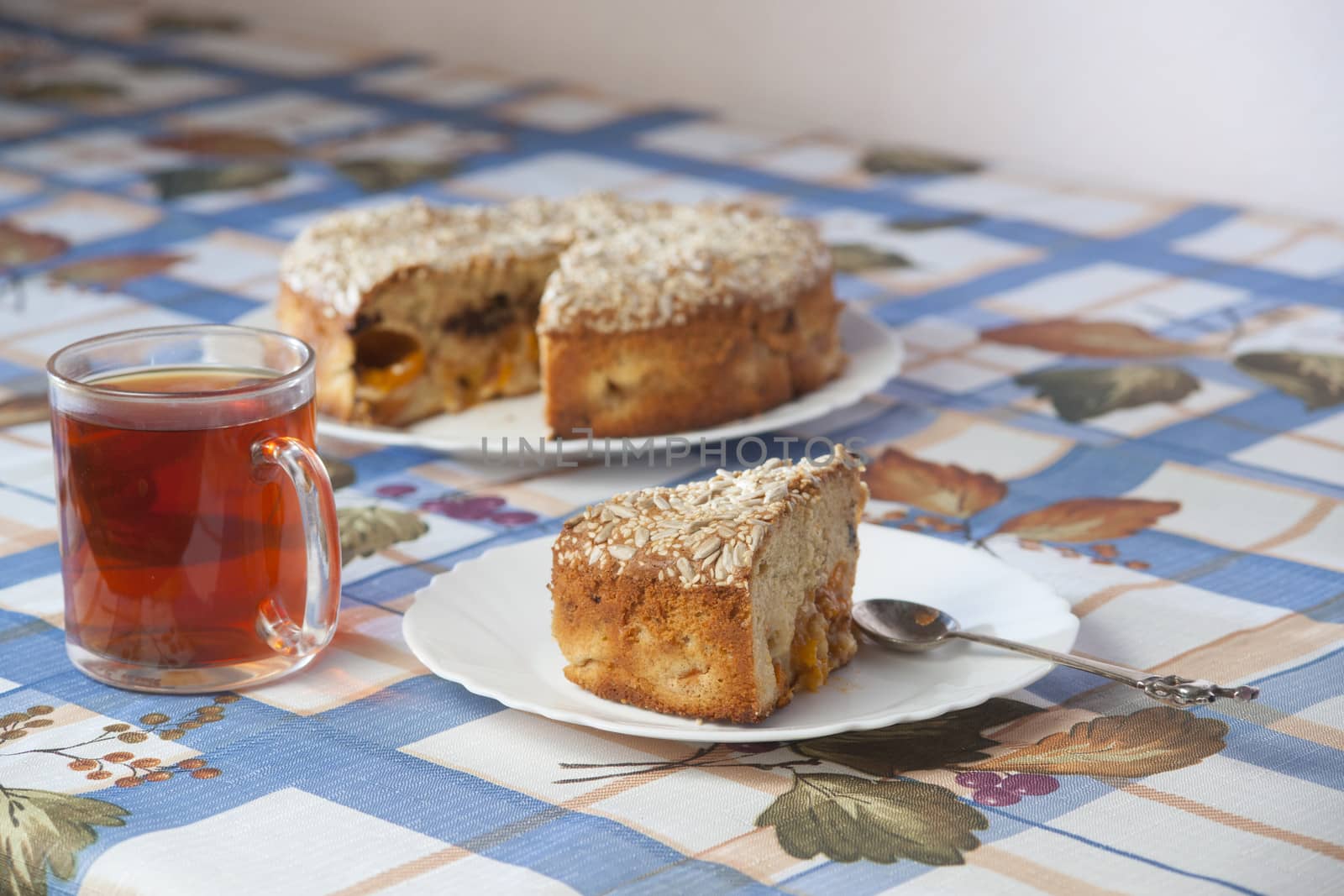 Apricot pie on plate and cup with tea. High resolution