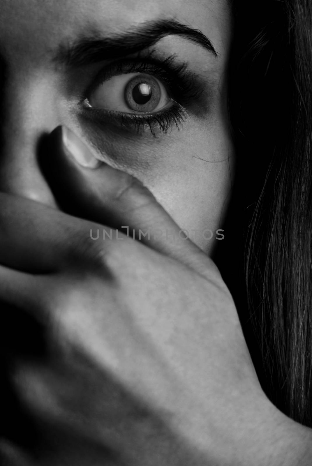 Horror monochrome photo of the afraid woman with mouth covered by hand