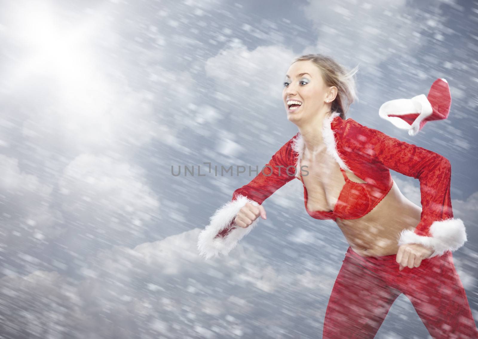 Running lady in Santa Claus costume under the heavy blizzard with cap blowing out