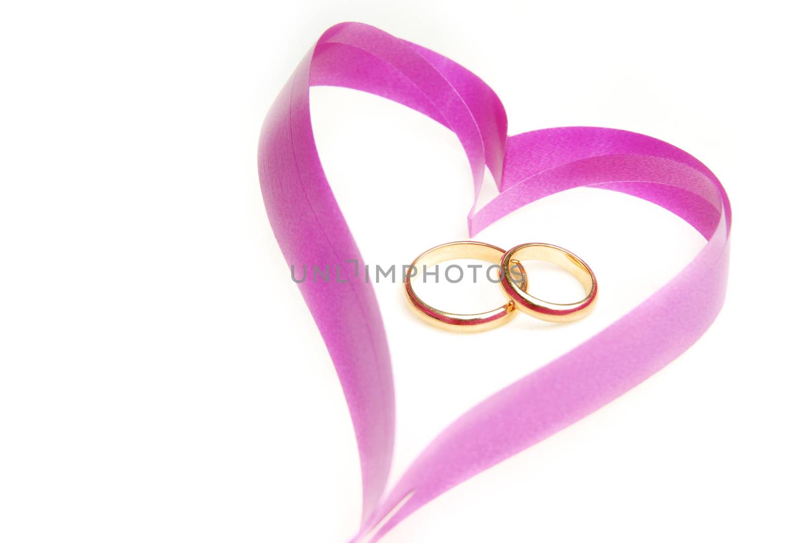 Close-up photo of the ribbon heart with wedding rings