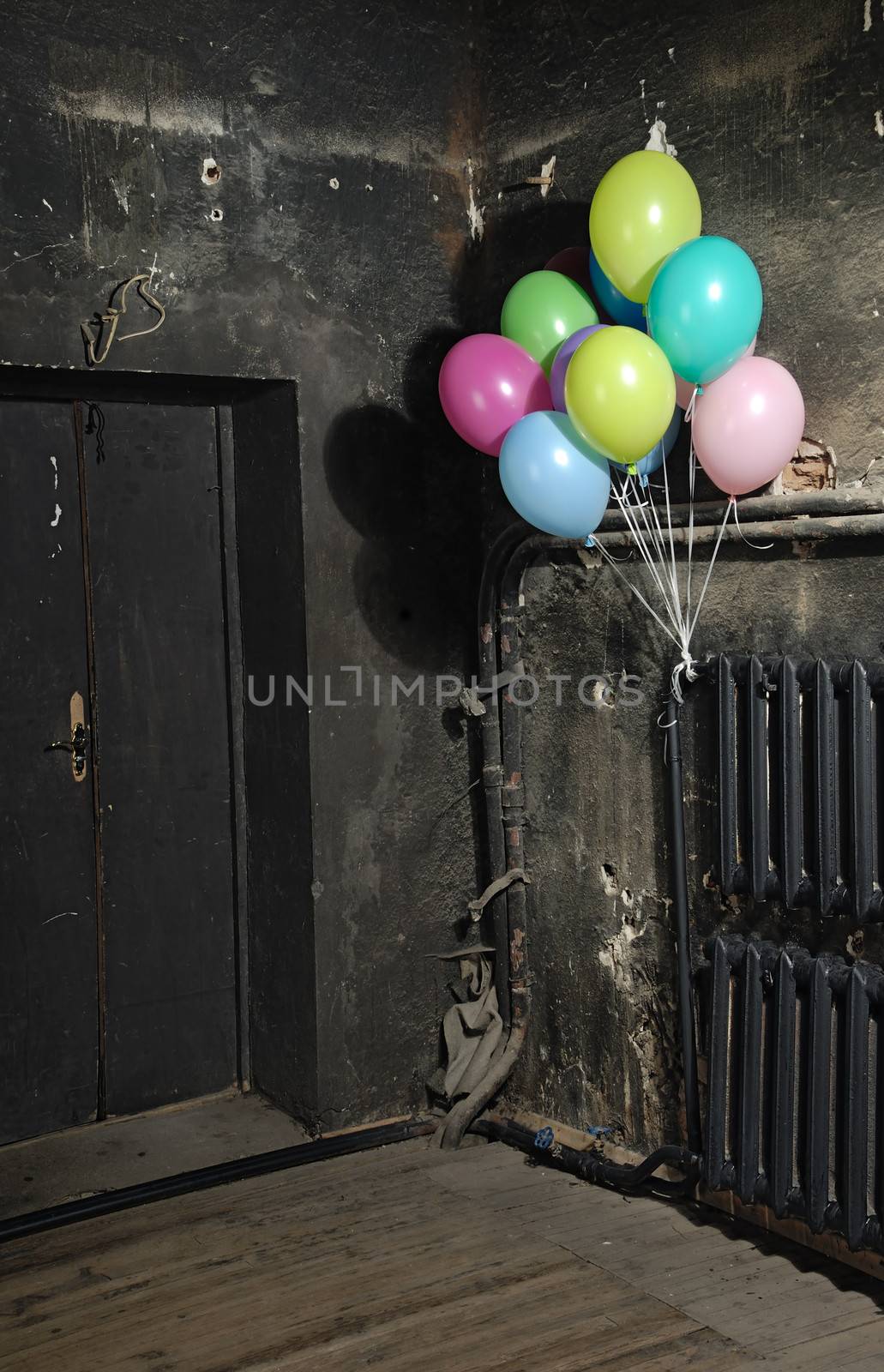 Celebrating colorful balloons in trashy dark interrior for Halloween