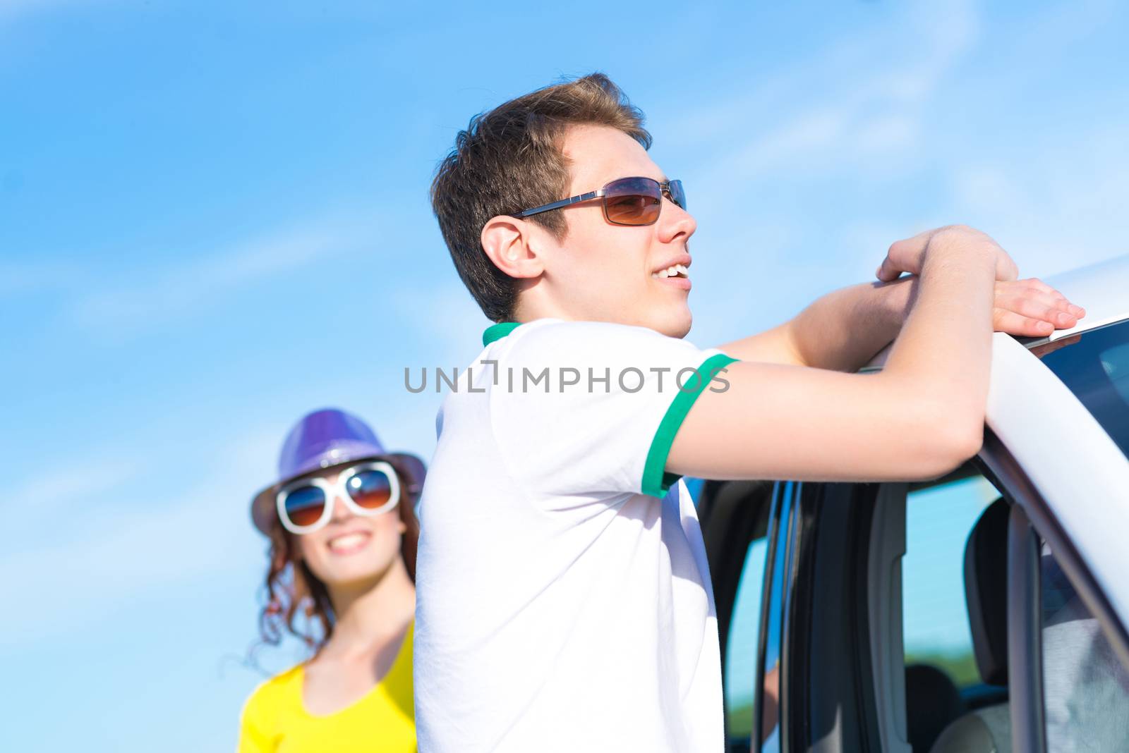 young man in sunglasses standing next to the car, the summer road trip