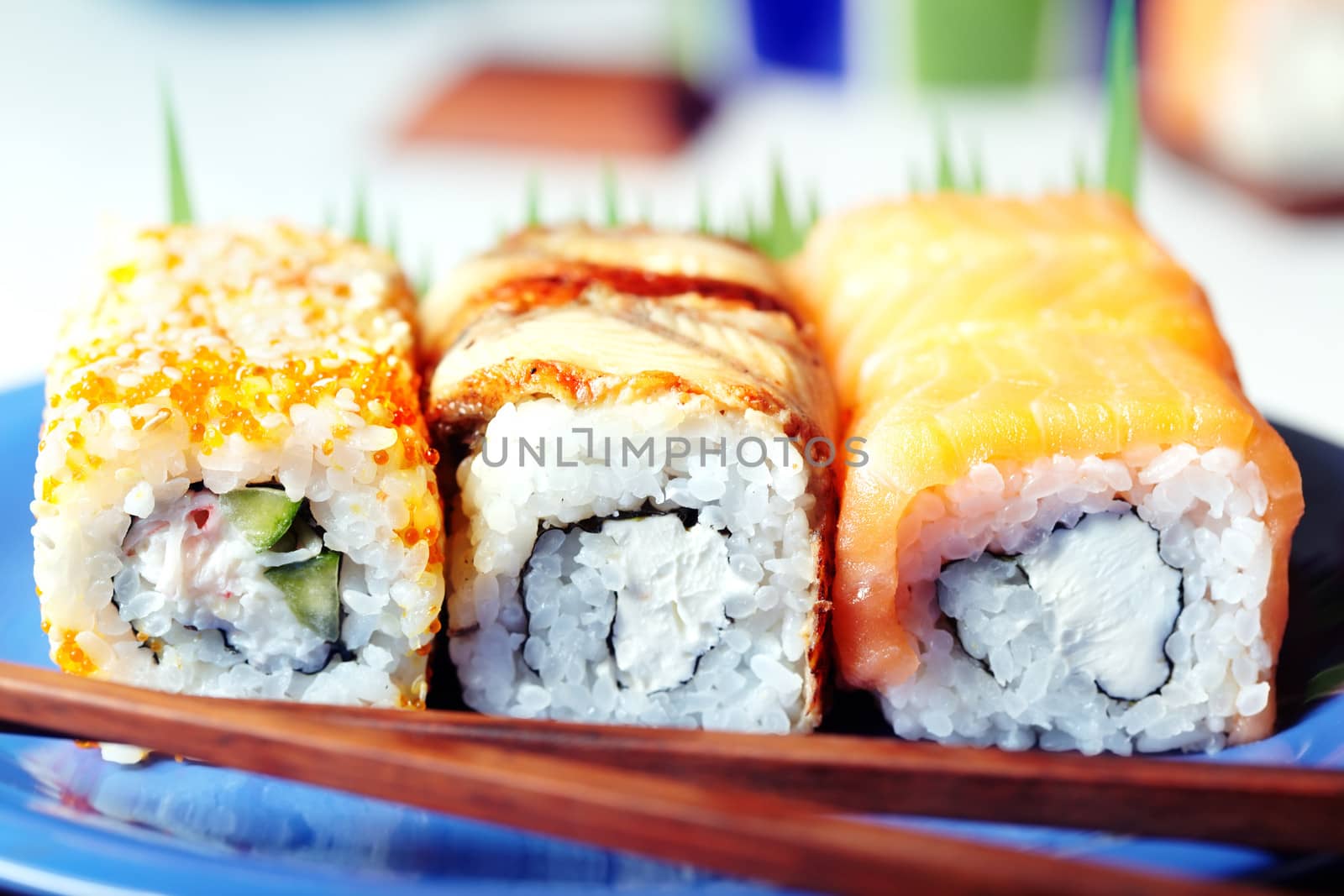 Close-up photo of the Japanese sushi set with chopstick on a blue table. Shallow depth of field for the natural view