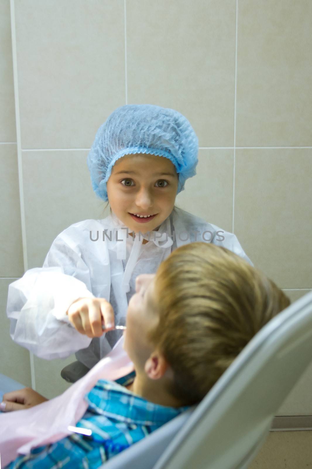 A couple of kids playing doctor at the dentist