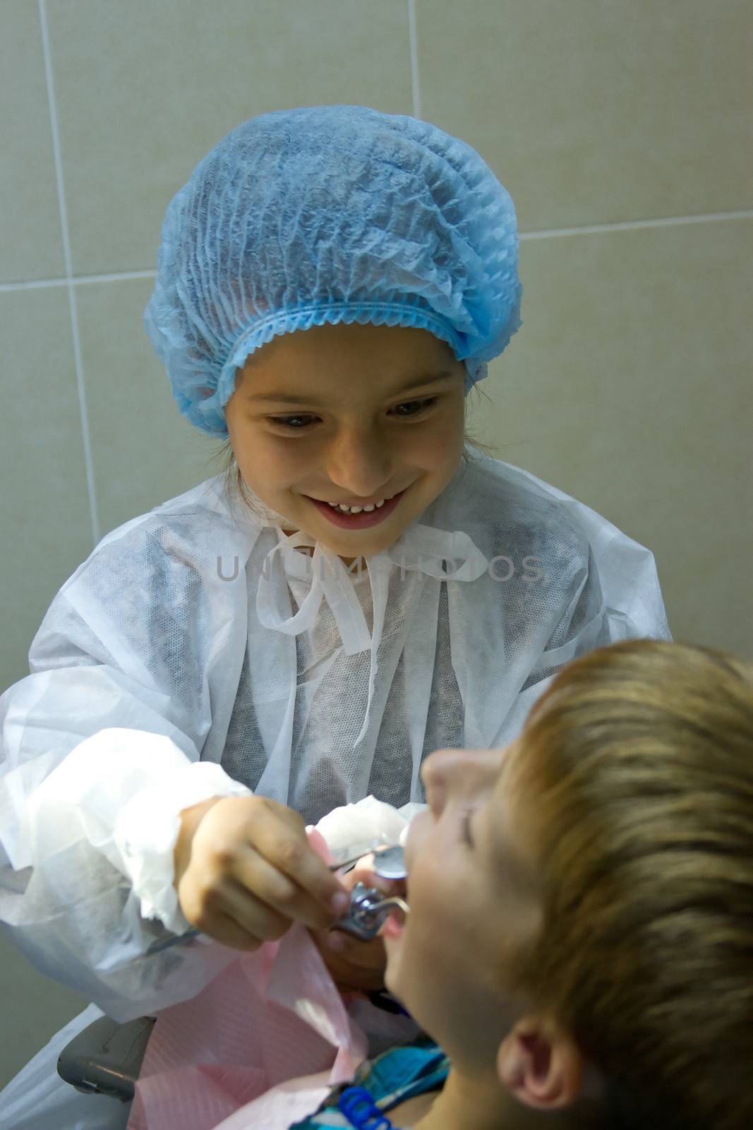 A couple of kids playing doctor at the dentist