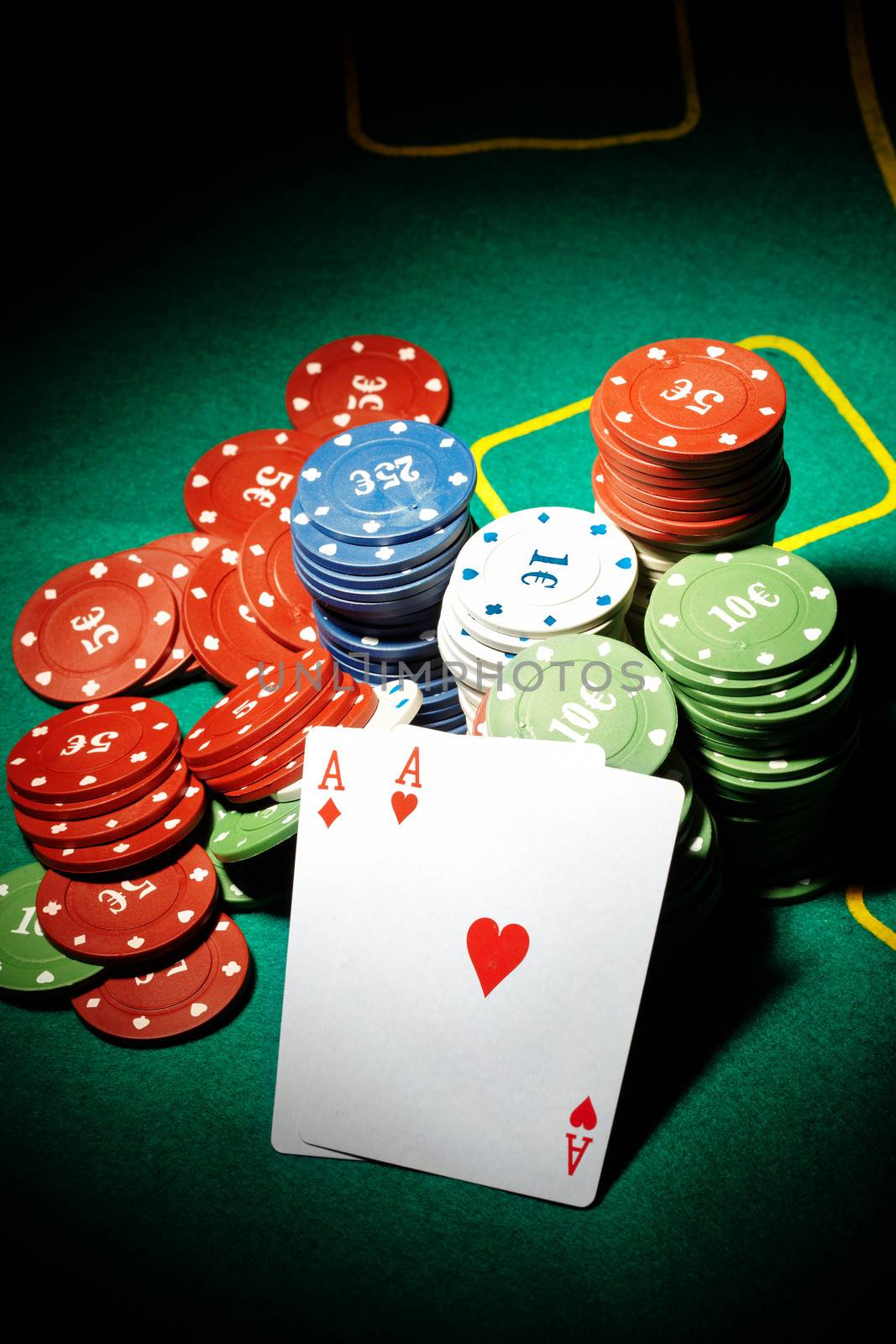 Pair of aces and poker chips on a green table in casino