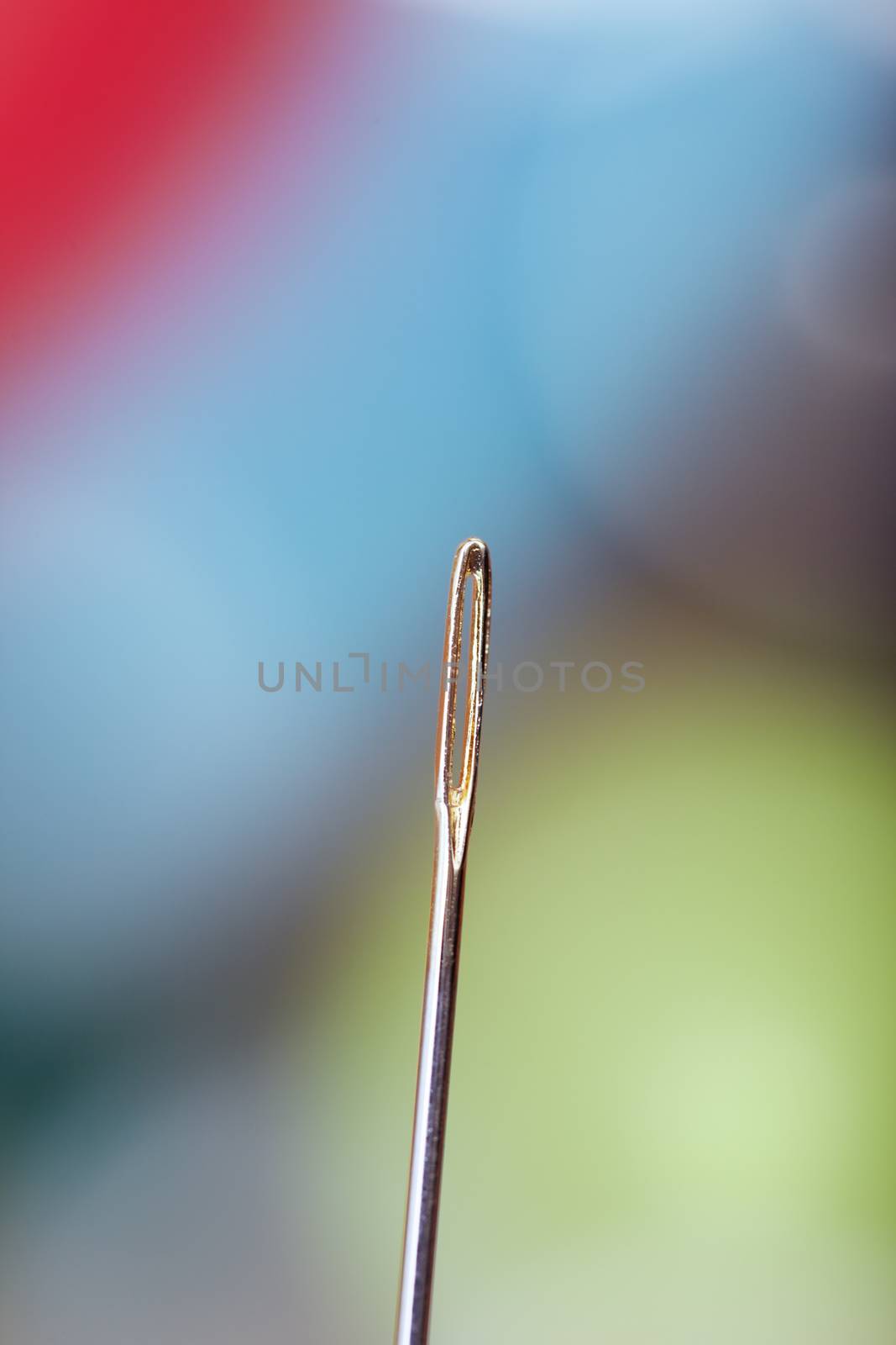 Sewing needle on a colorful background. Extremely close-up photo