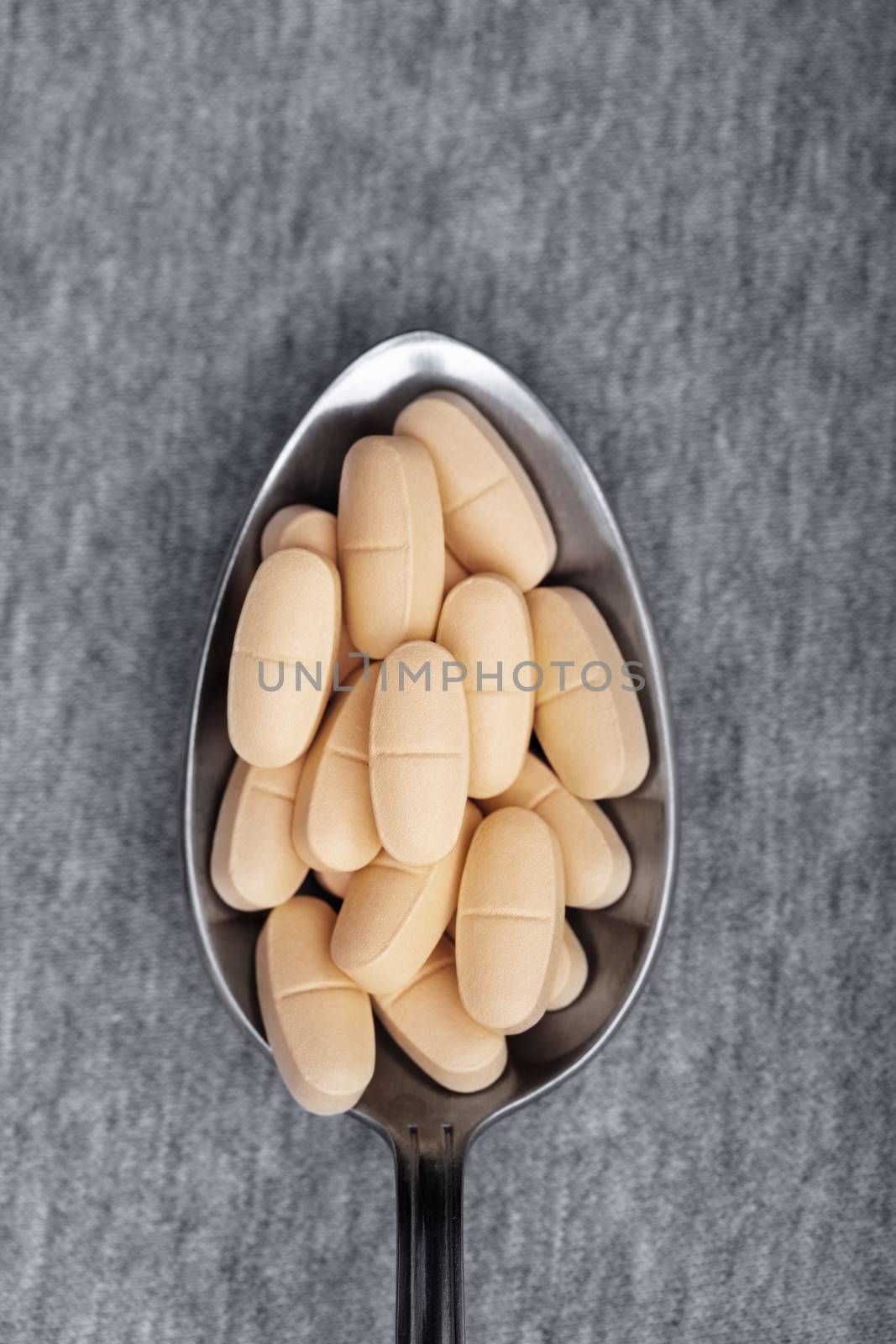 Medical pills on a metal spoon. Close-up photo