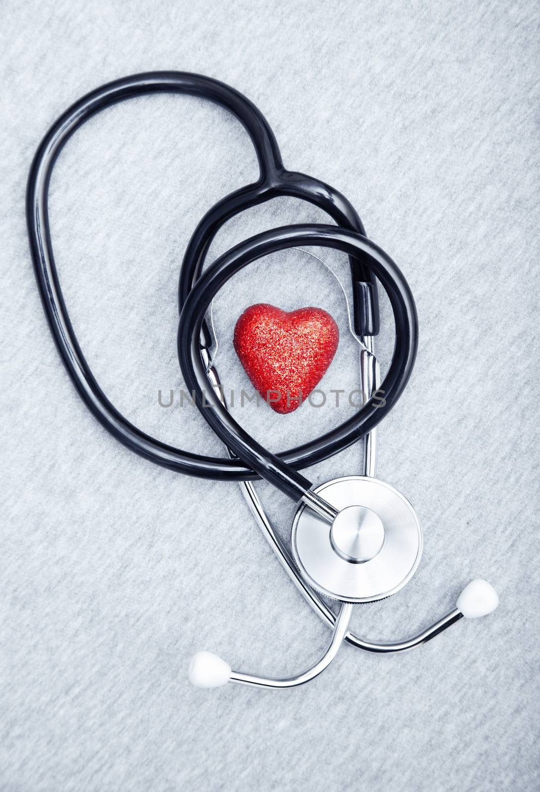Medical stethoscope and heart on a textured background