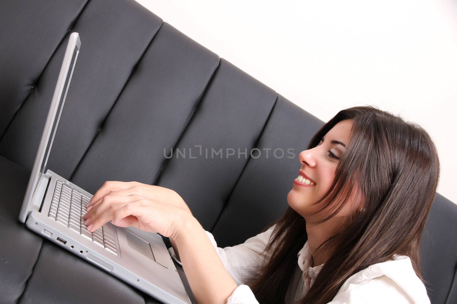 A young woman surfing on the Internet with a Laptop.  
