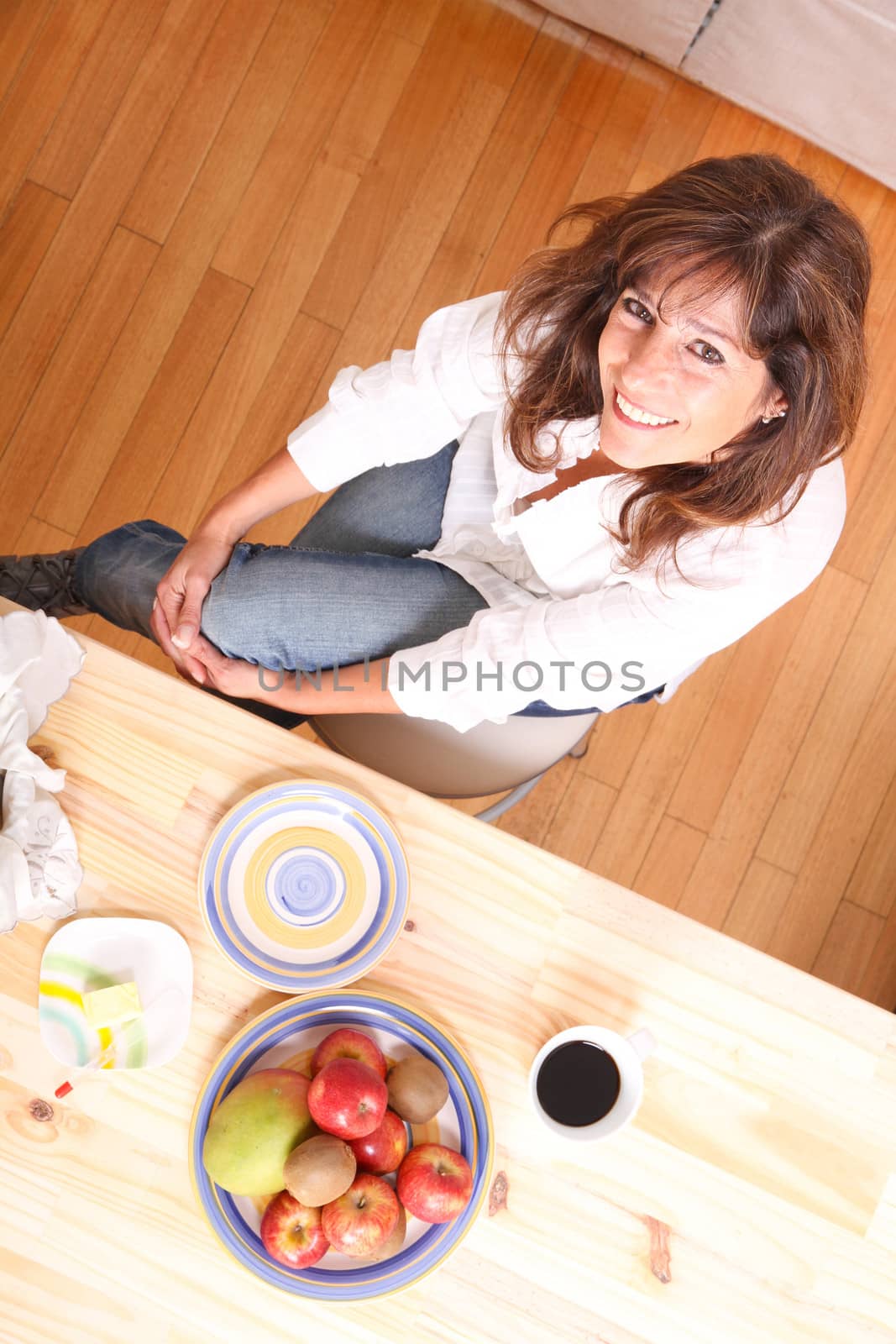 Portrait of a beautiful mature woman sitting in the kitchen. 