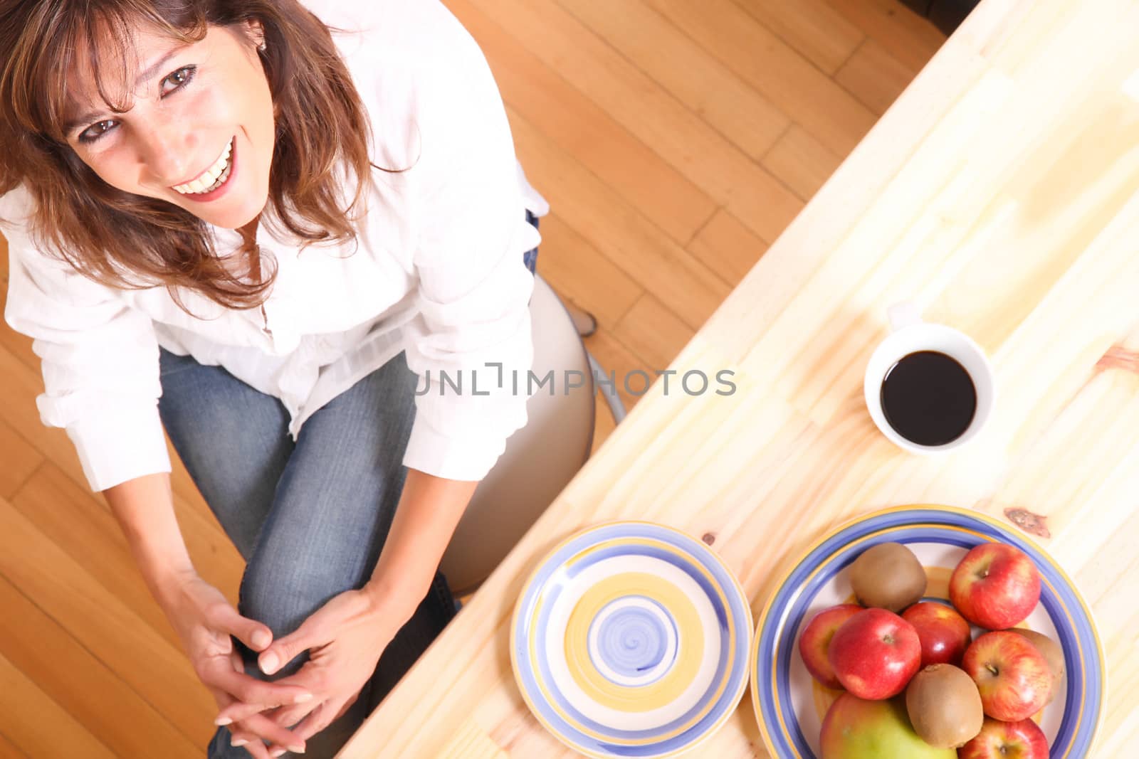 Portrait of a beautiful mature woman sitting in the kitchen. 