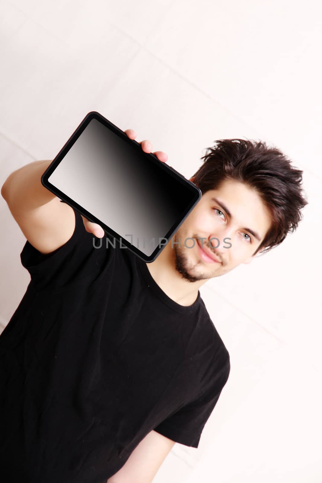 A young hispanic man holding a Tablet PC.