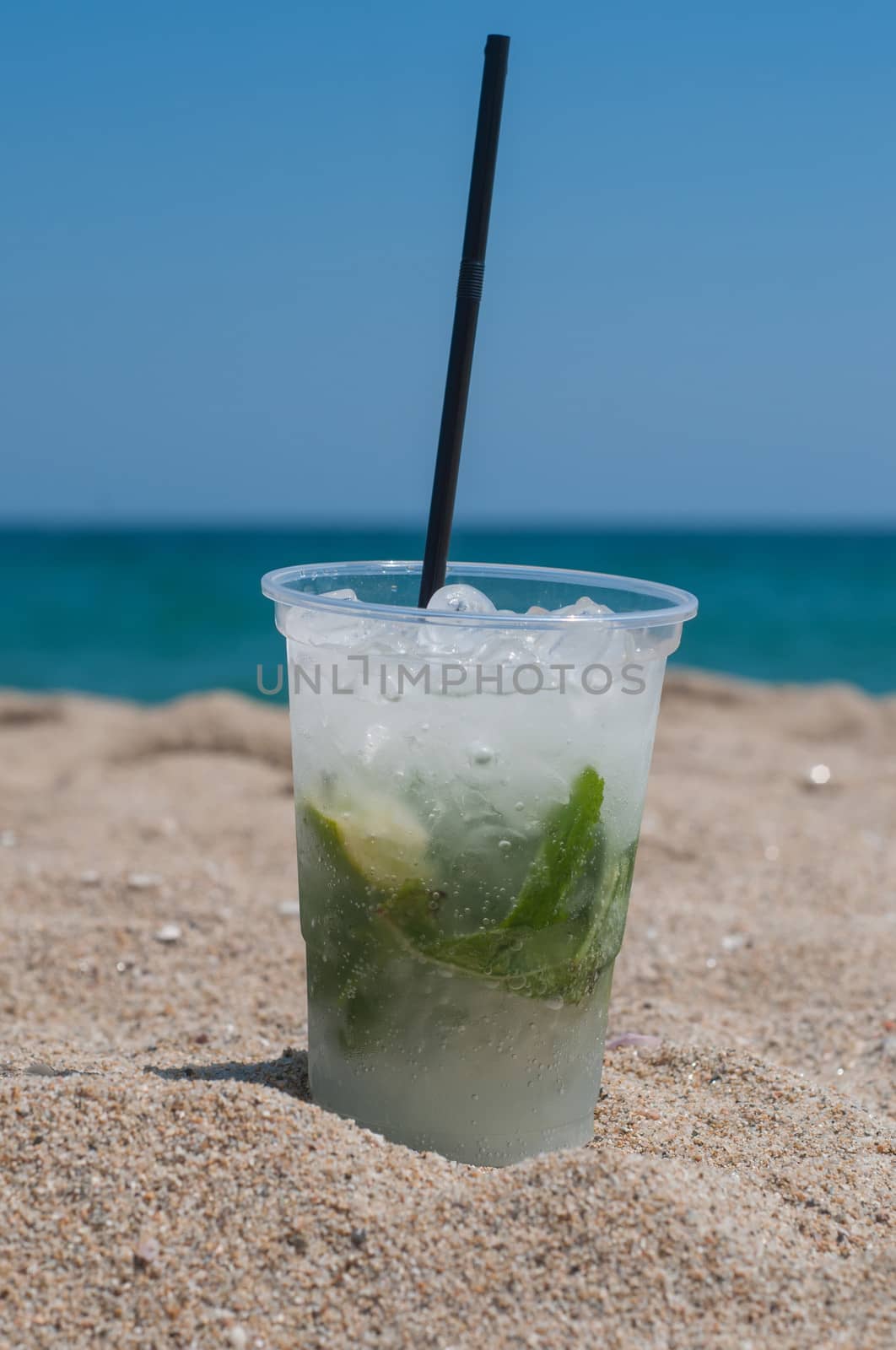 Shot of Mojito cocktail on the beach