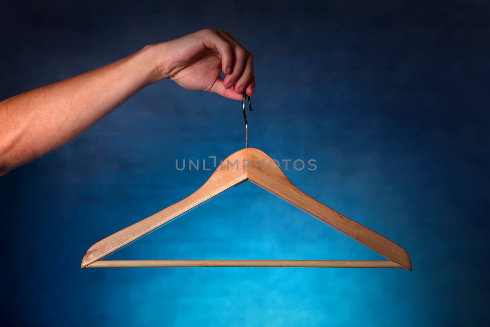 Clothes Hanger in a hand on the dark background