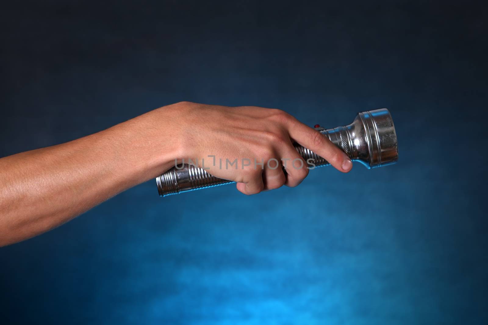 Hand with Flashlight on the dark background