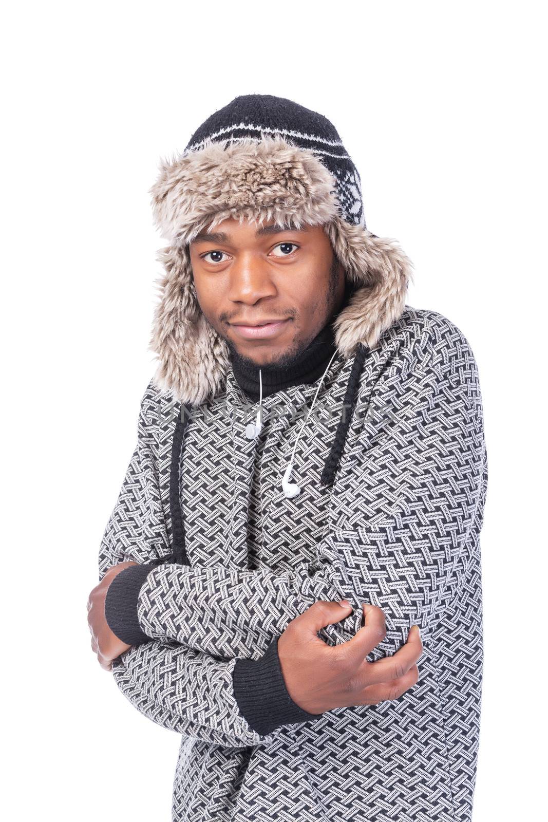 Young African-American wearing winter clothing but feeling cold in a white background