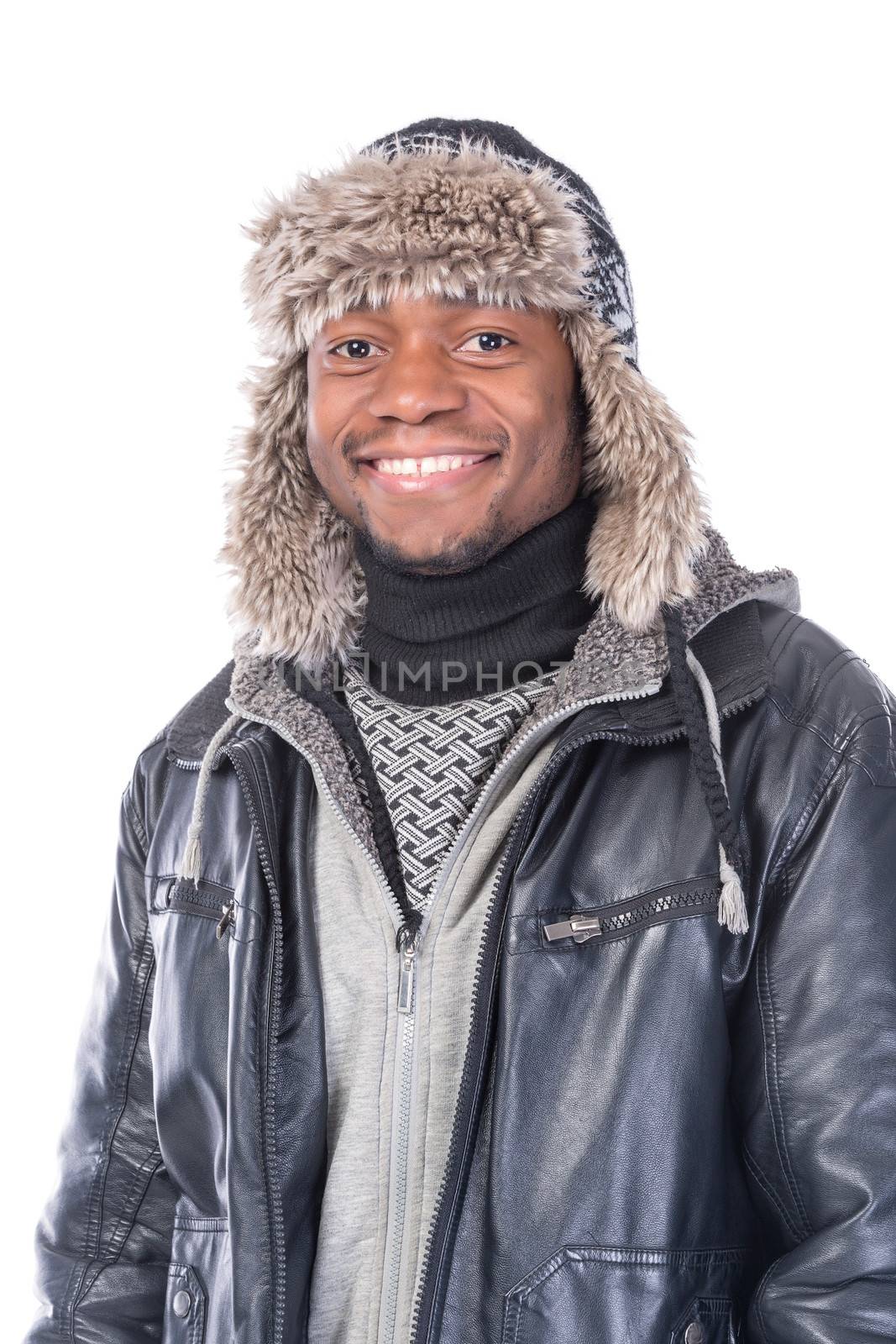 Young African-American wearing winter clothing but feeling cold in a white background