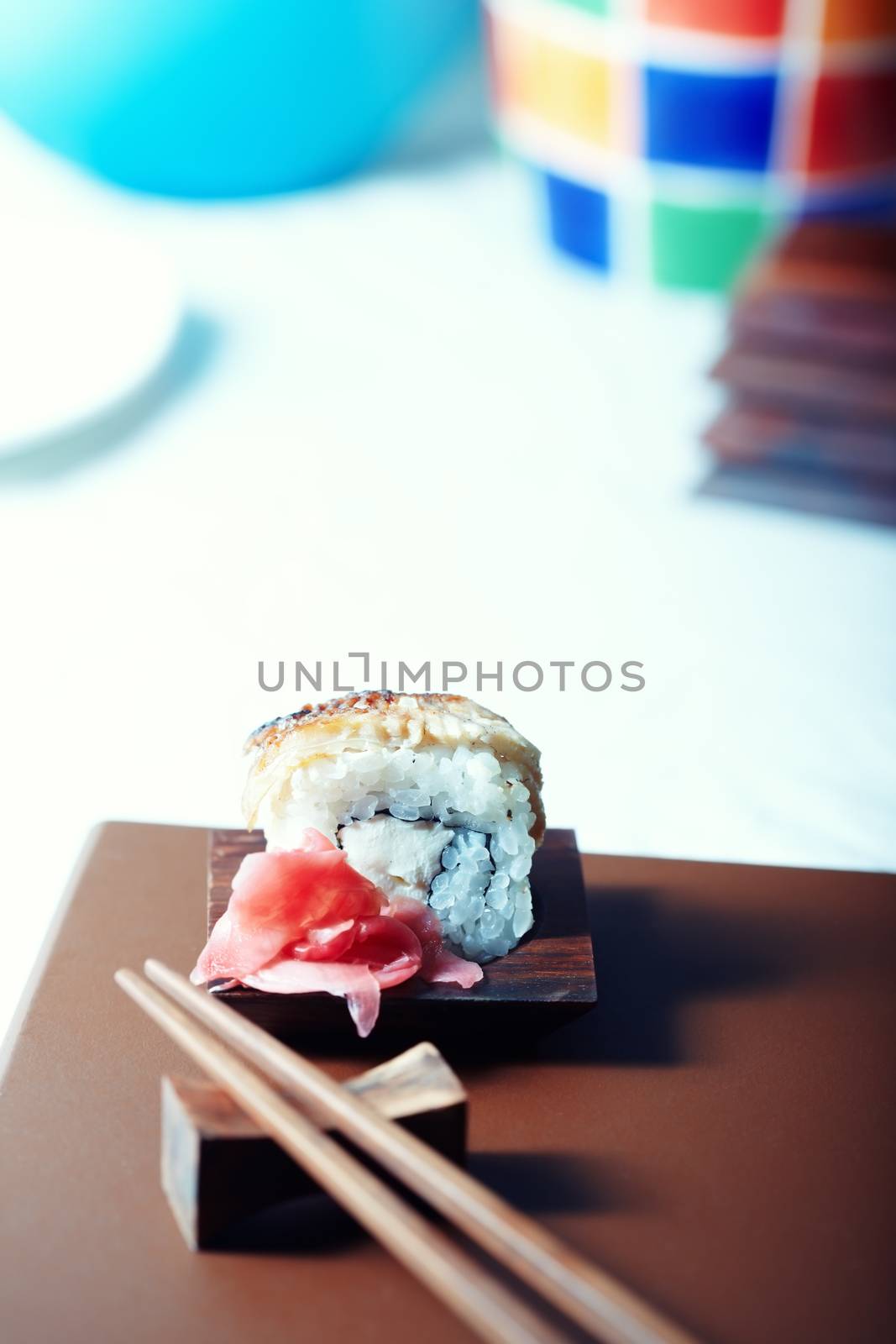 Close-up vertical photo of the rolled sushi with rice and cucumber on the table. Shallow depth of field for natural view