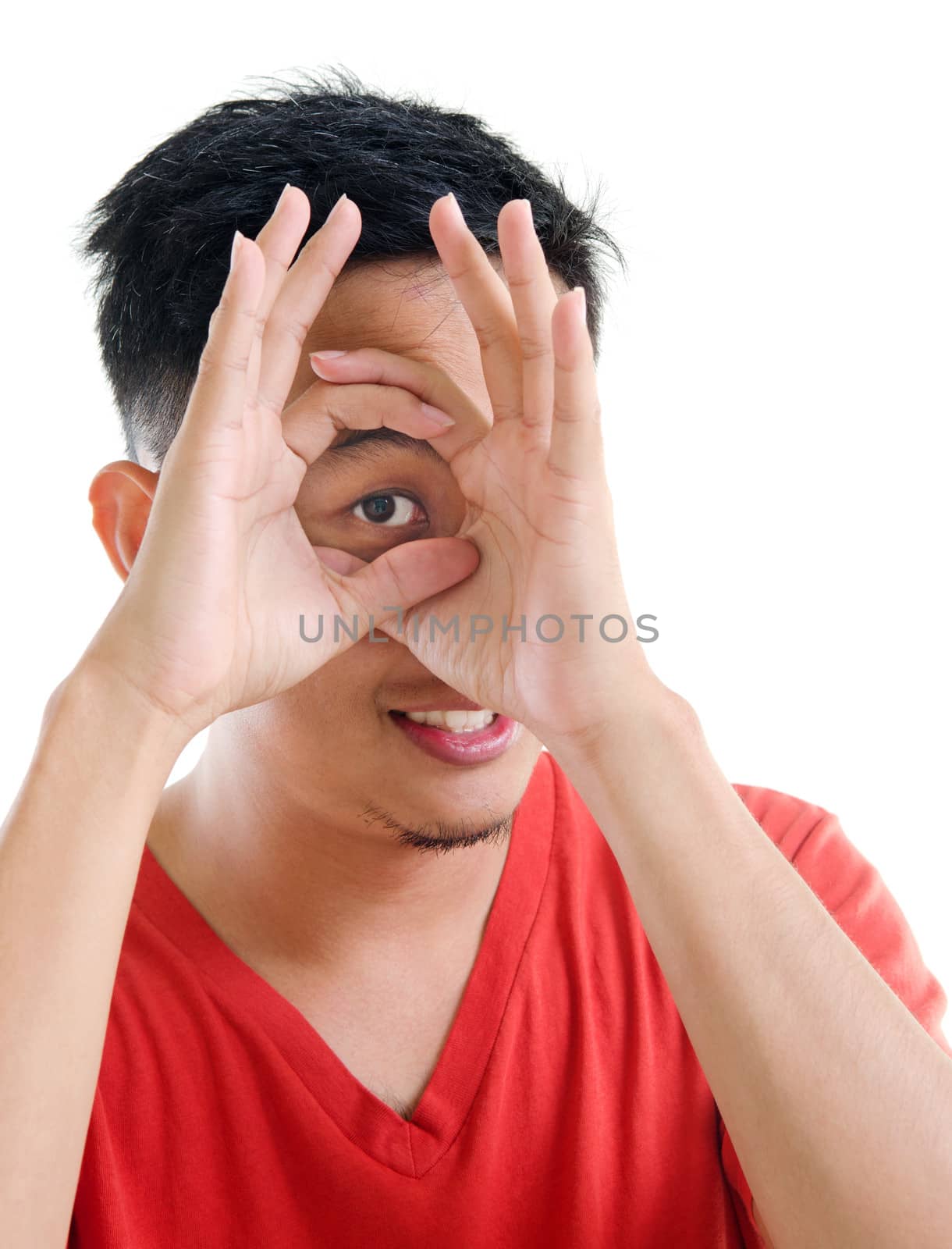 Asian man peeping through fingers hole, isolated on white background