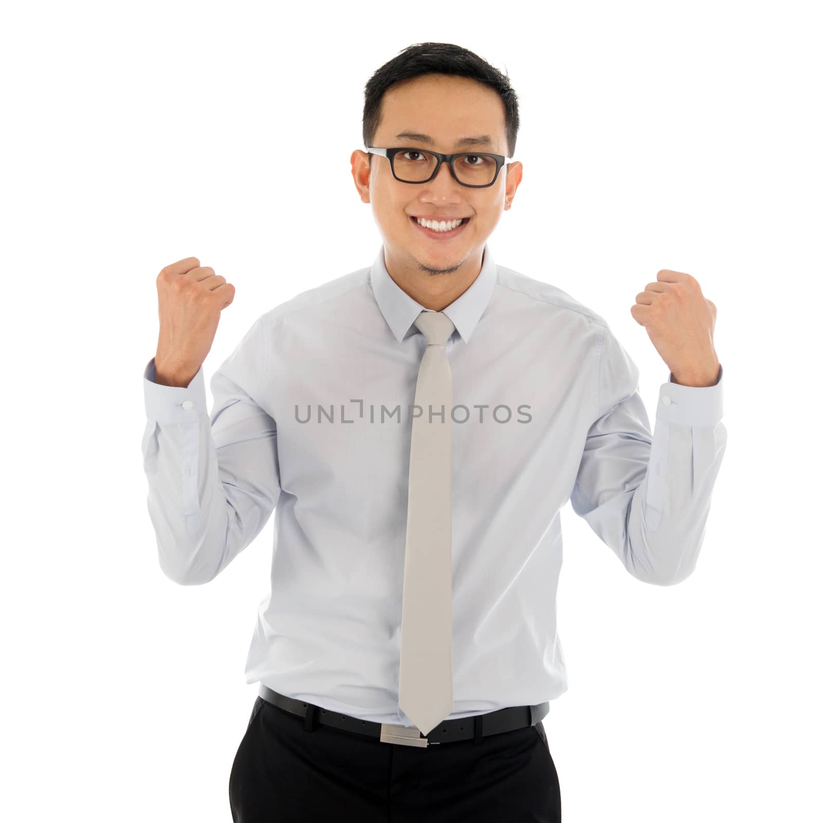 Portrait of excited Asian business male celebrating success isolated over white background