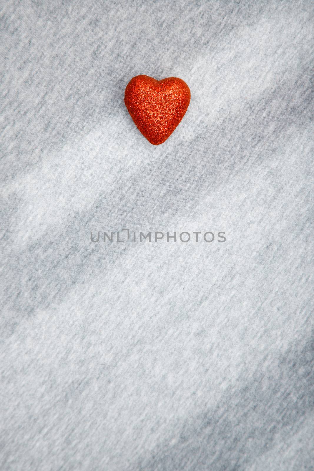 Red heart of love on a textured background with shadows